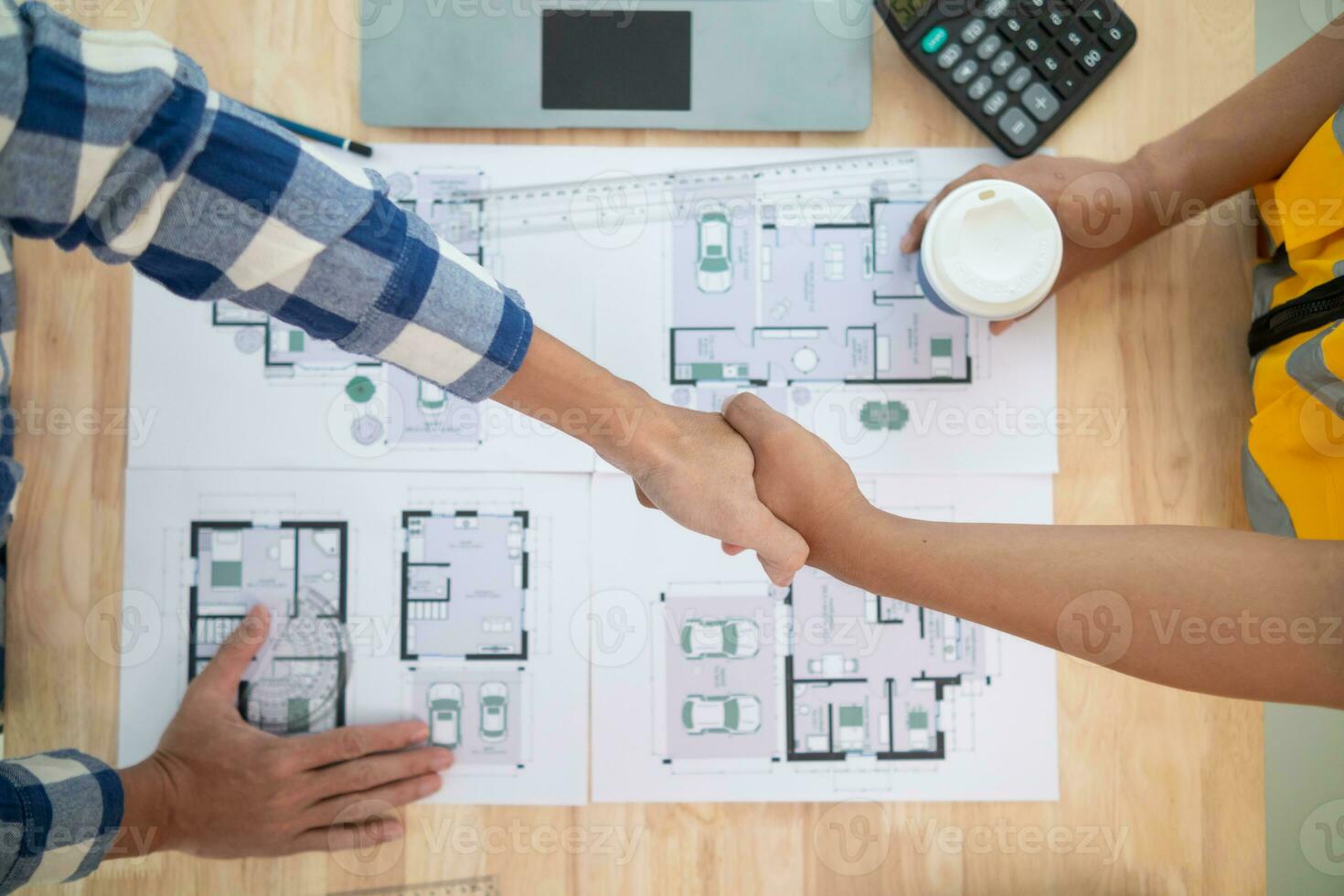 construction engineer joins hands with architect to congratulate housing project that architect team has designed and has been accepted by engineering team. concept of handshake for congratulations photo
