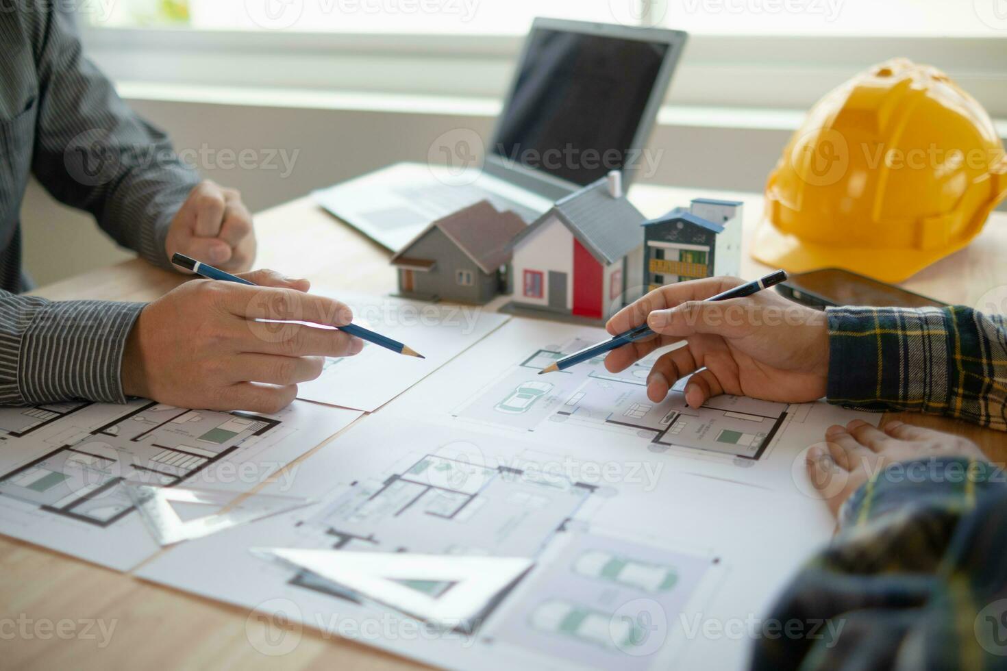 Construction engineers discuss and exchange ideas with architects to improve house plans to meet customer needs. A concept for exchange of design ideas between construction engineers and architects. photo