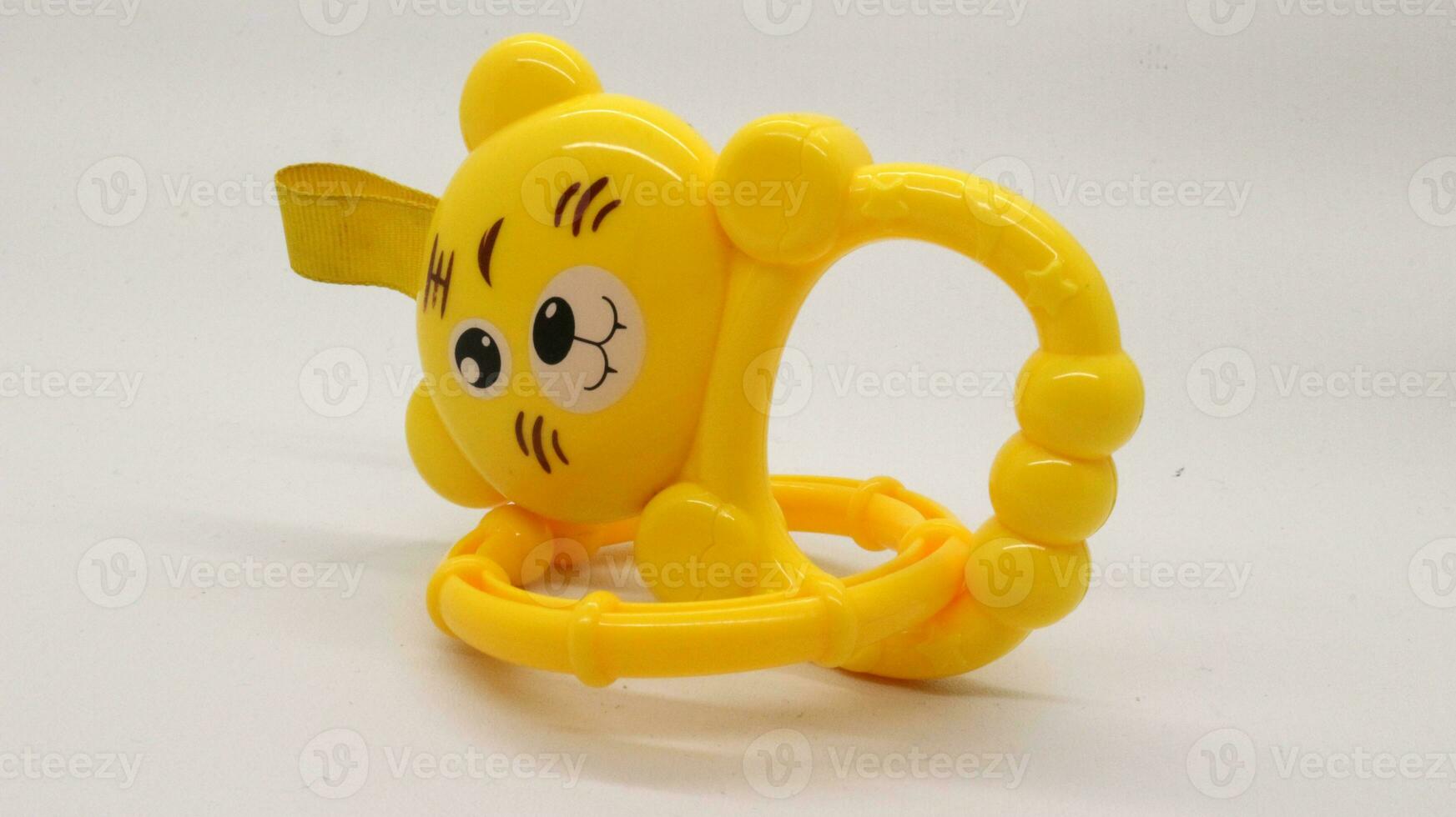 Yellow baby holding toy with bear shape isolated photo