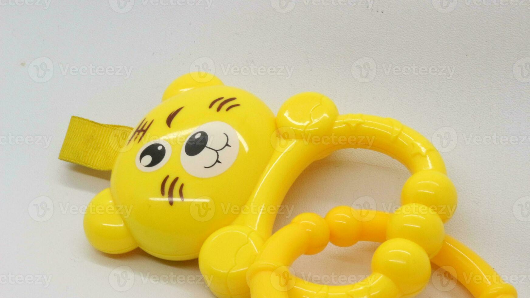 Yellow baby holding toy with bear shape isolated photo