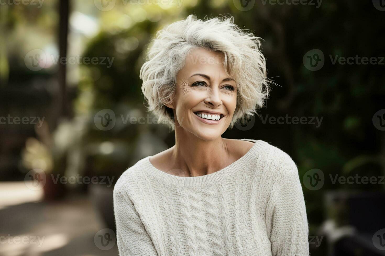 AI generated A radiant mature woman with stylish short white hair, wearing a casual sweater, displays a vibrant smile in a lush outdoor setting photo