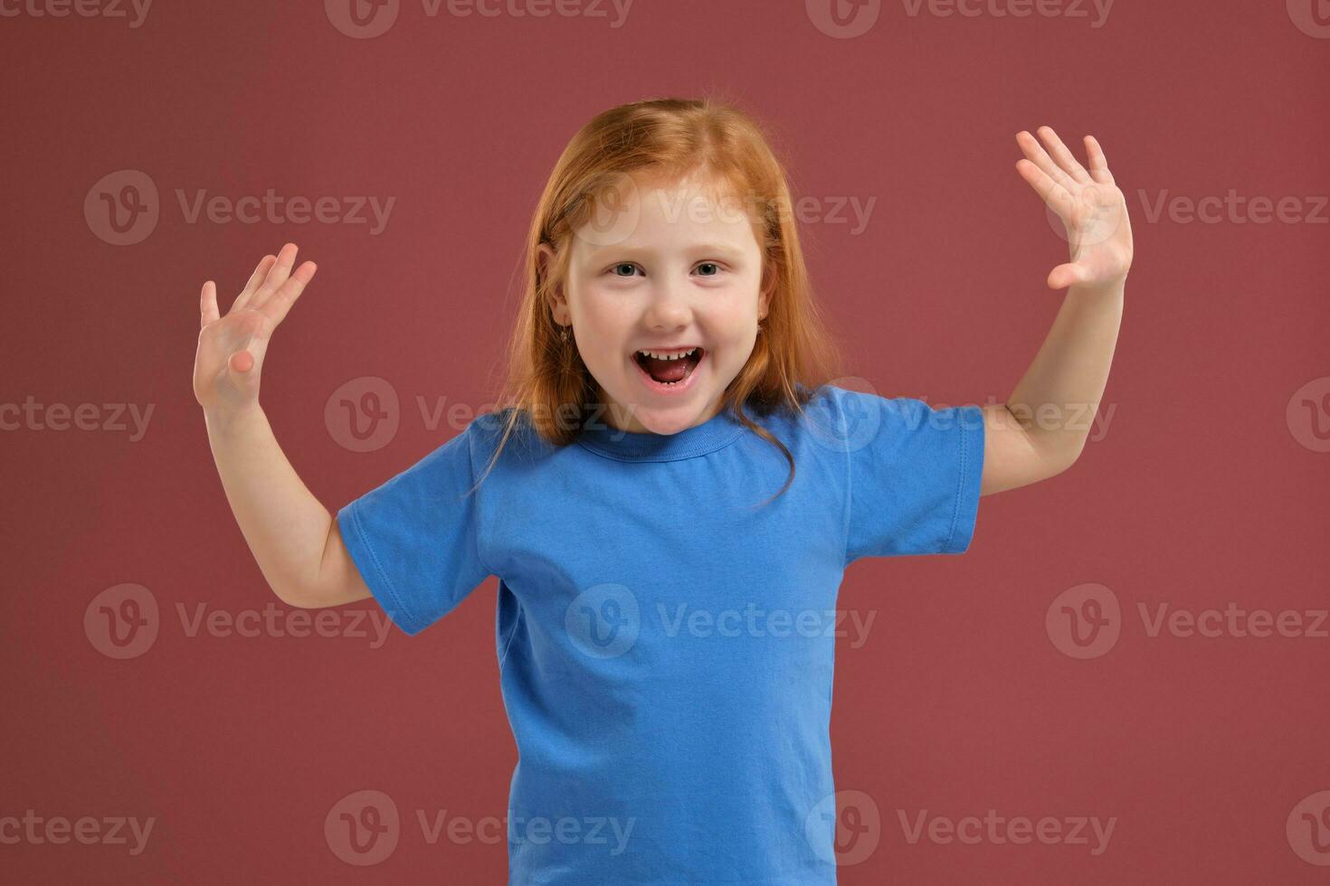 Portrait of cute redhead emotional little girl on red background photo