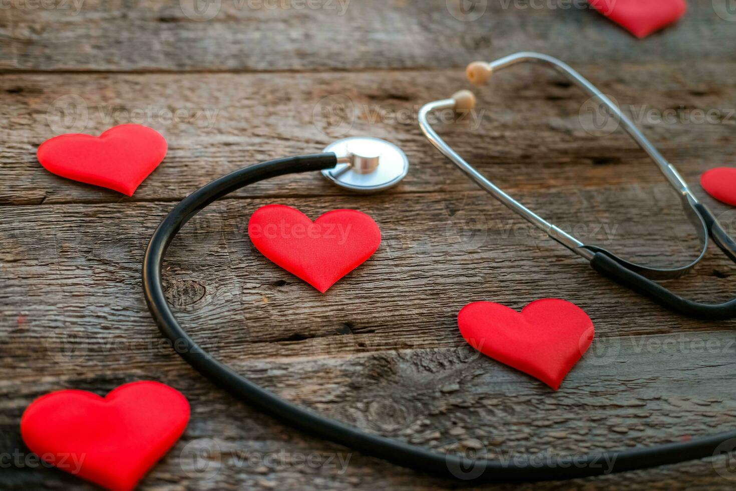 Stethoscope and hearts on a wooden foen. Valentine day concept photo