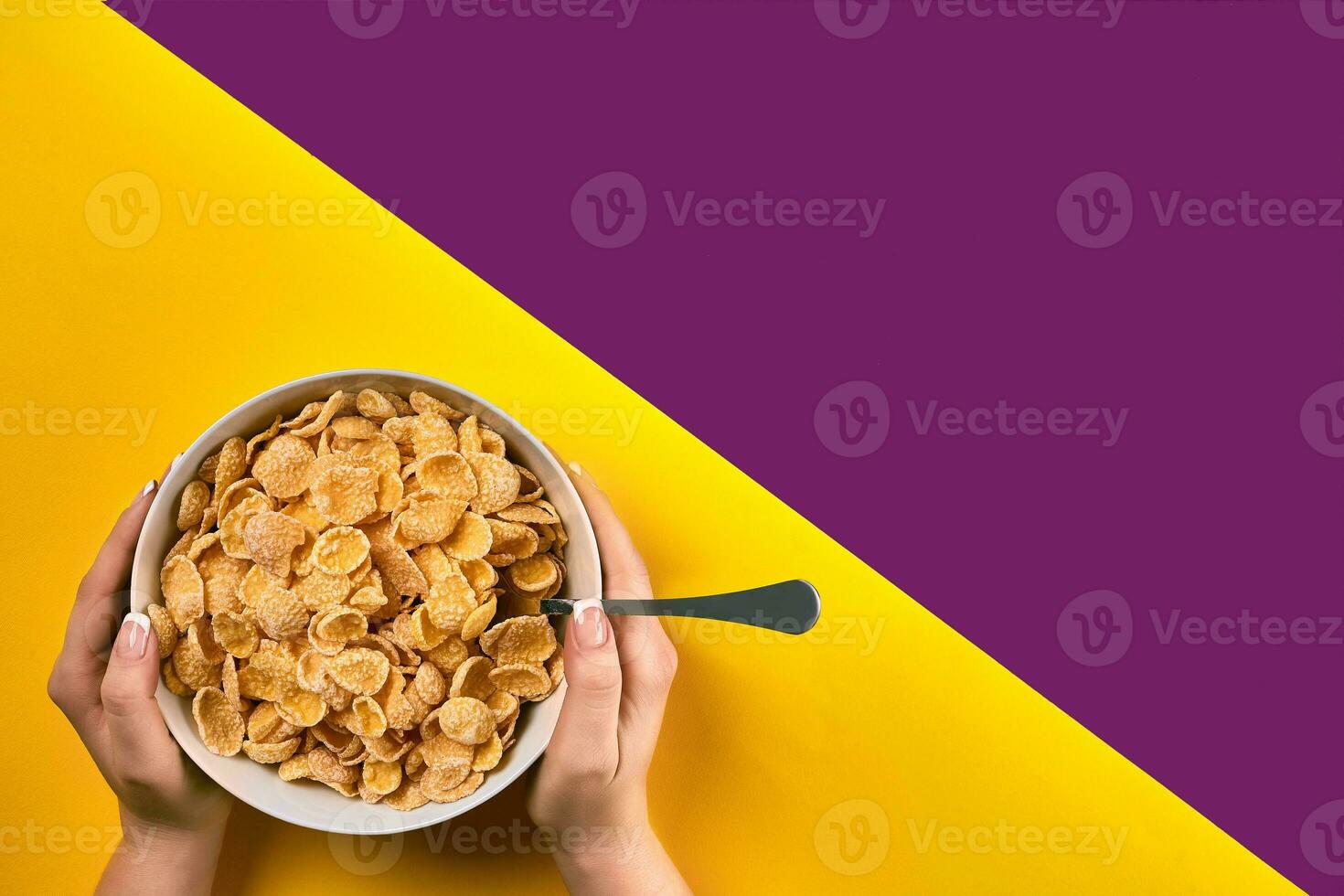 Food, healthy eating, people and diet concept - close up of woman eating muesli for breakfast over purple and yellow background photo