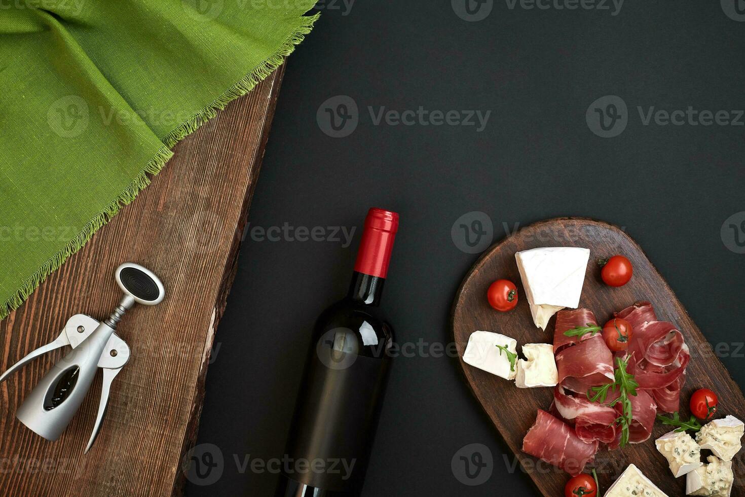 vino botella con queso y tradicional salchichas en de madera tablero en negro antecedentes con Copiar espacio foto