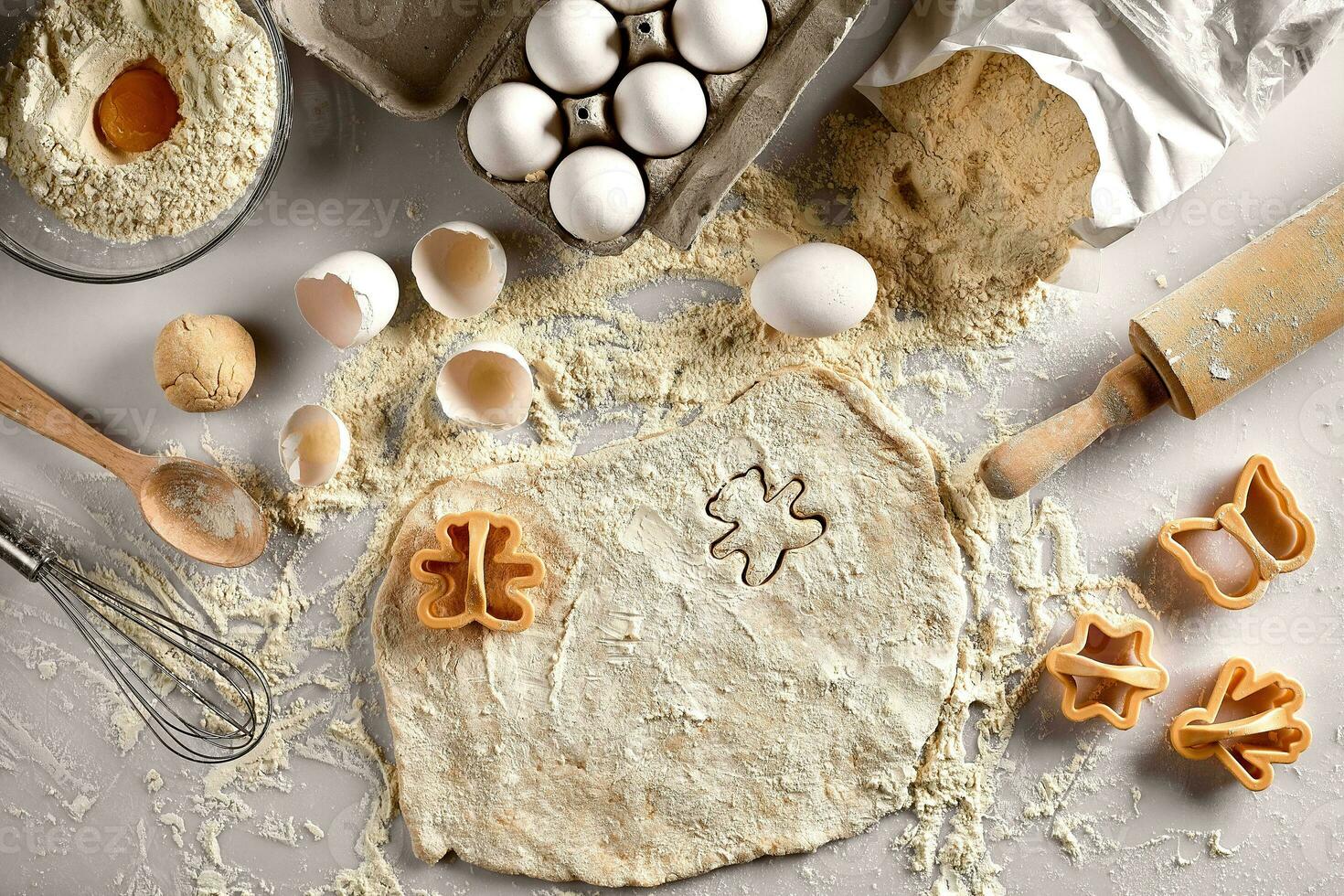 Baking concept raw dough for biscuit, eggs, flour, cutters in the shape of star and butterfly on a white table. Top view. photo
