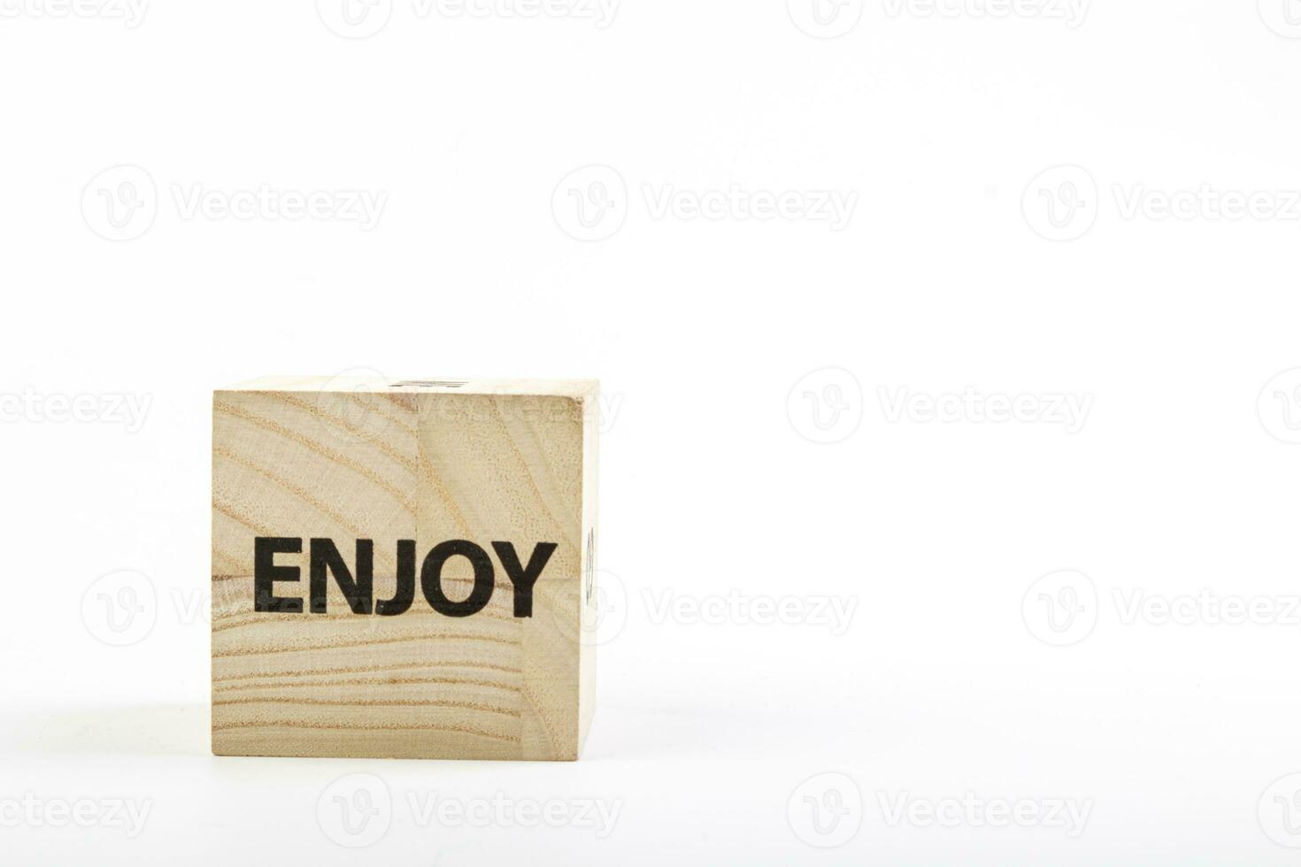 Wooden cubes with the inscription enjoy on a white background photo