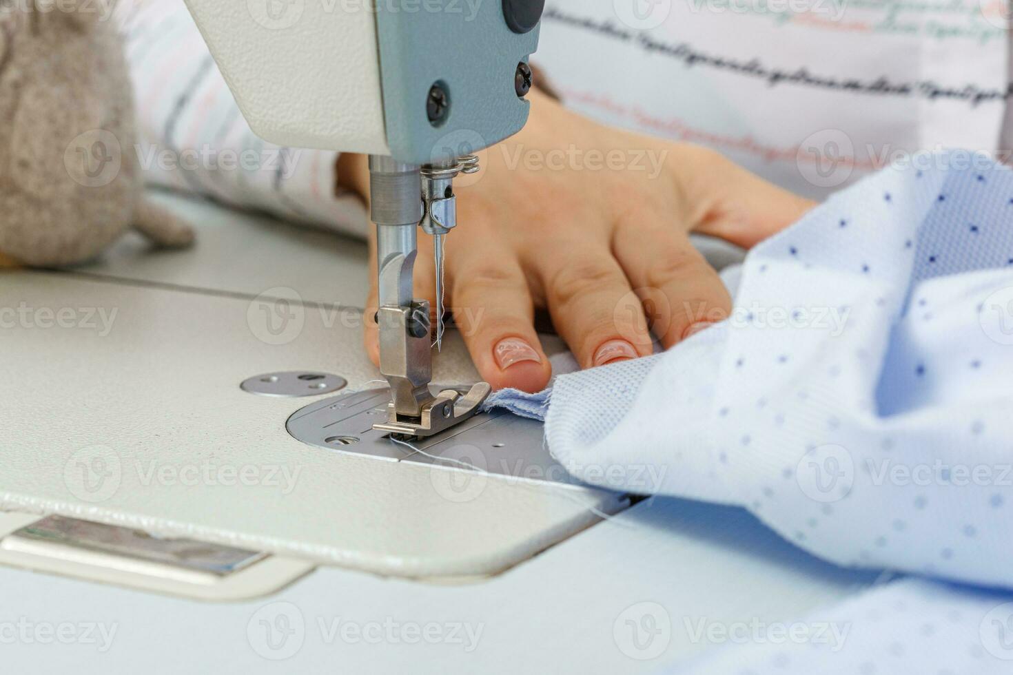 Female hands of a master tailor at work, a sewing machine needle photo