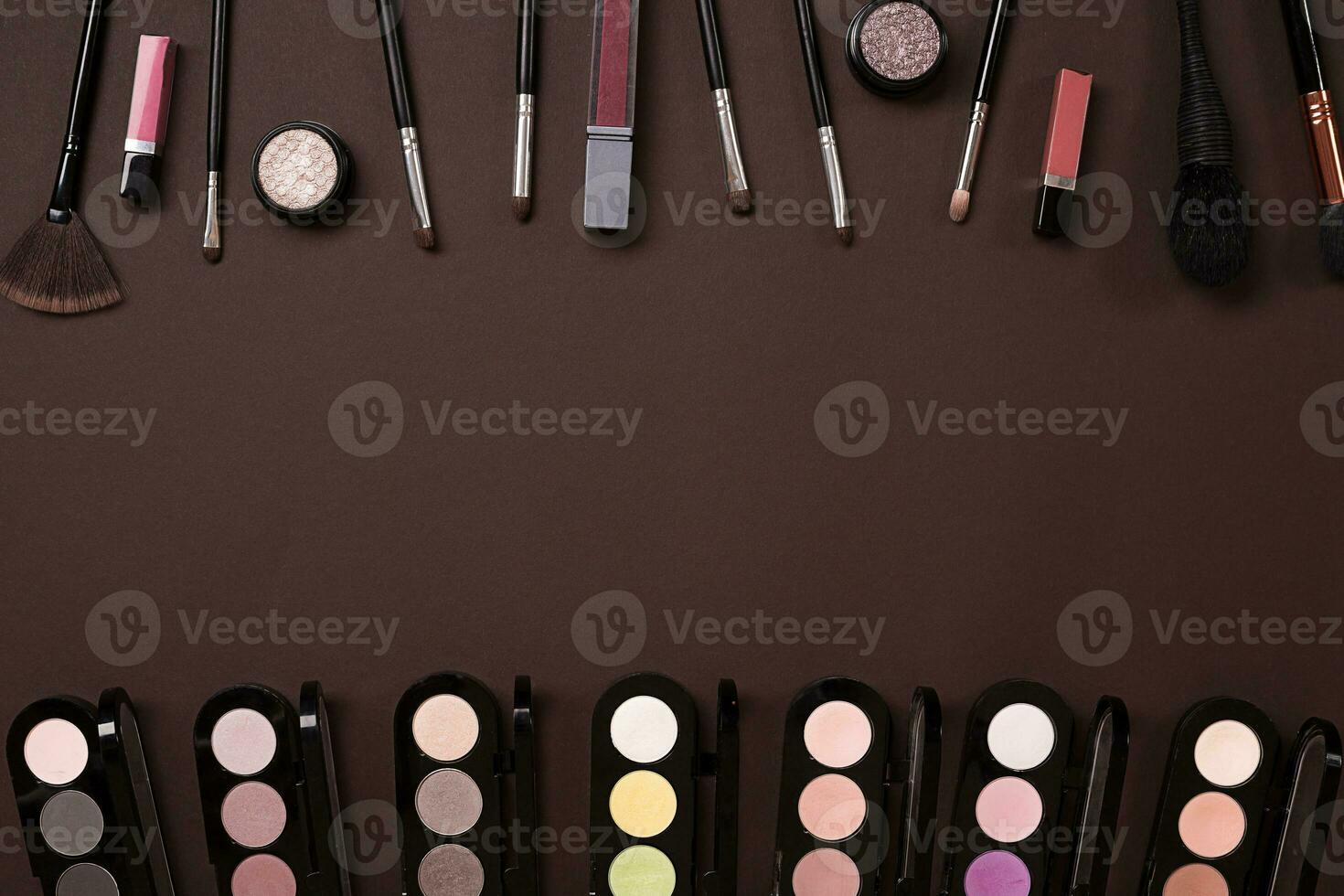Top view on set of cosmetics for professional make-up on brown background photo