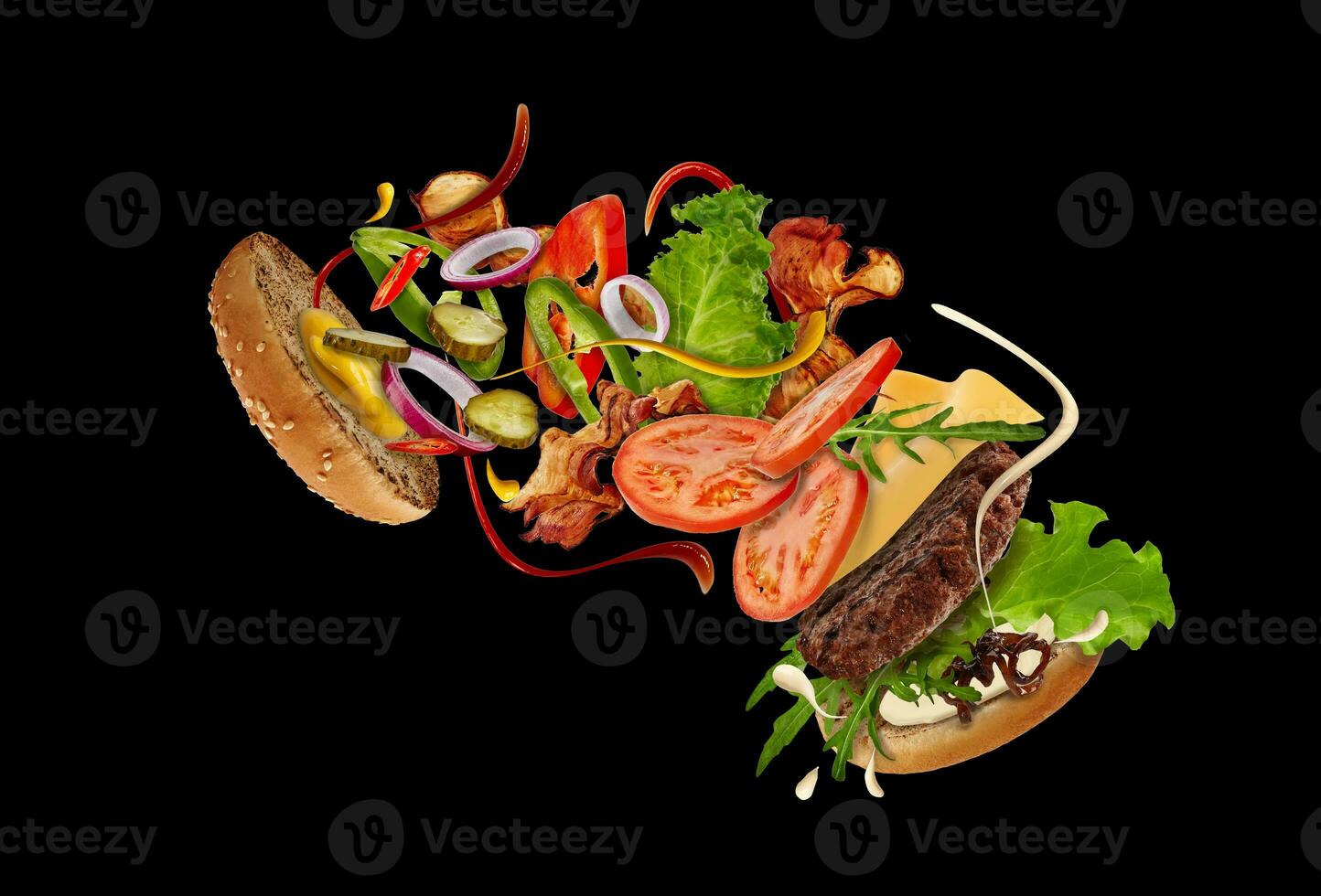 Big burger with flying ingredients on black background. Ham, beef cutlet, cheese, mayonnaise, ketchup, vegetables and greens. Close up, copy space photo