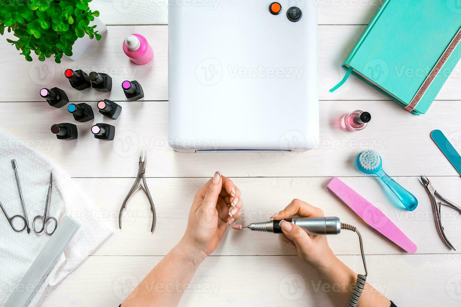woman hands making manicure to herself on wooden background. photo