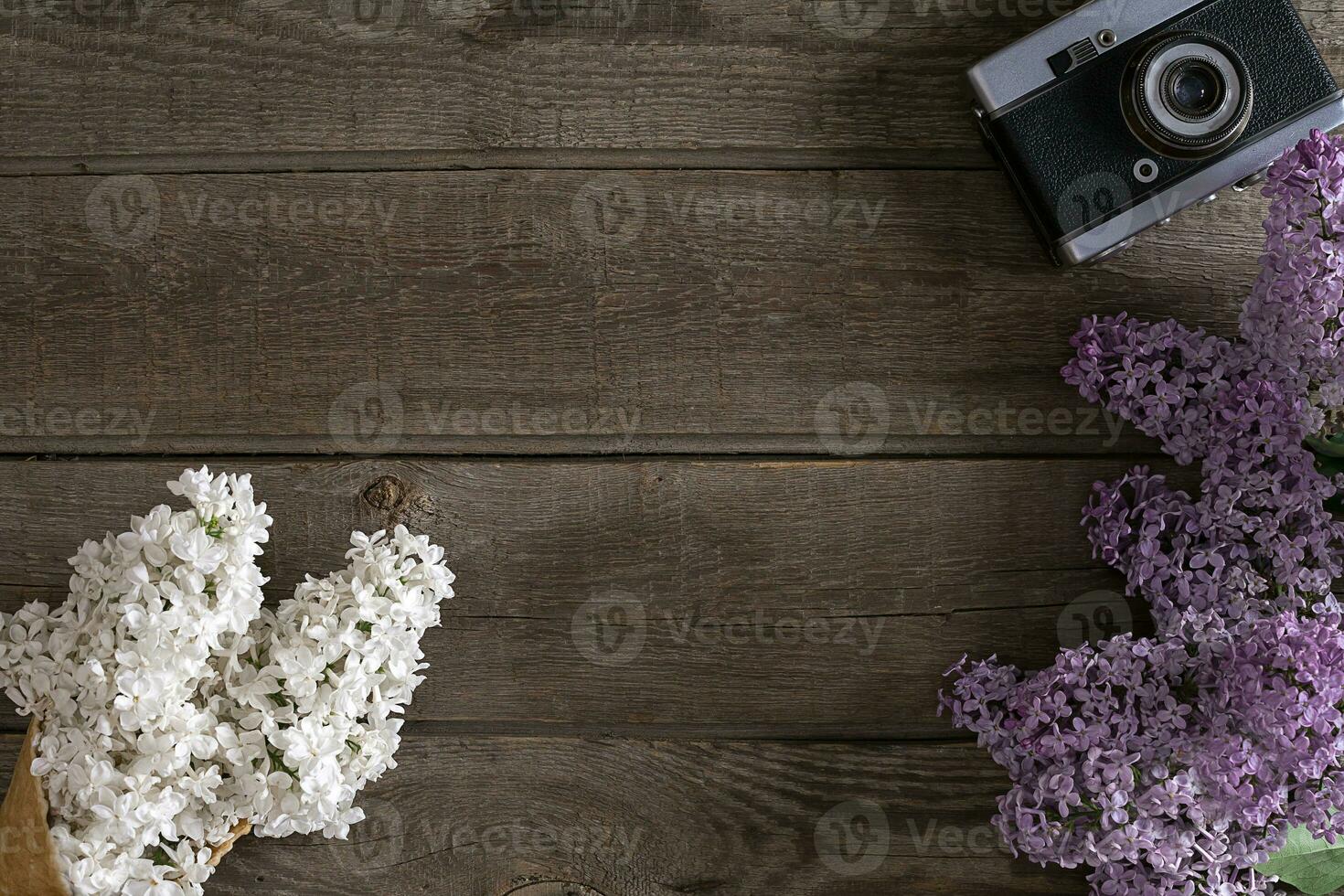 Lilac blossom on rustic wooden background with empty space for greeting message. Top view photo