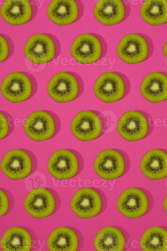 Pattern of kiwi. Top view of the sliced kiwi on pink background. Minimal flat lay concept. photo