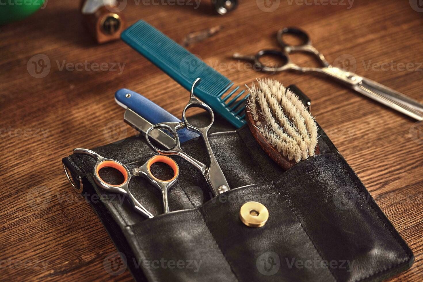Hairdresser tools on wooden background. Top view on wooden table with scissors, comb, hairbrushes and hairclips, trimmer. photo