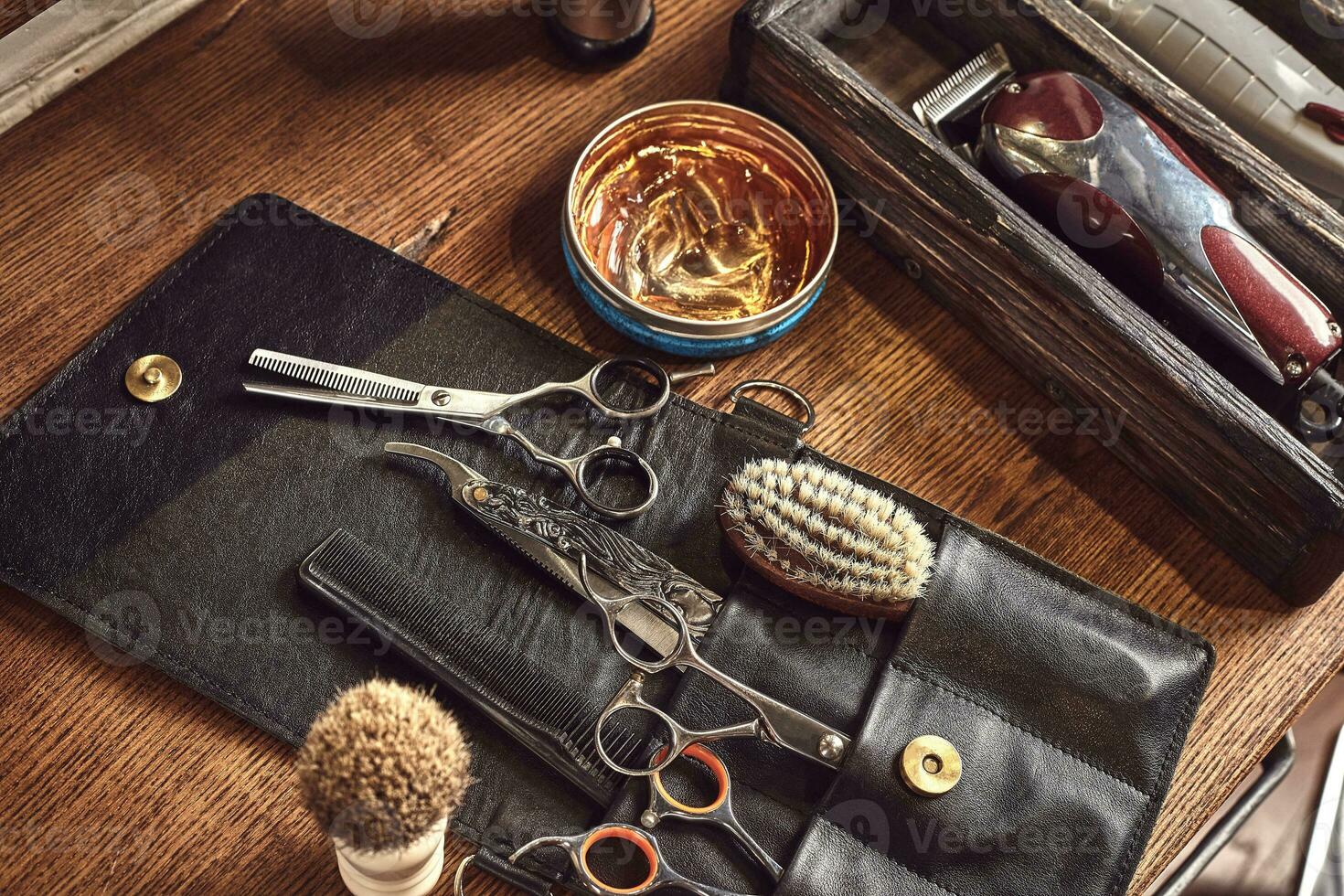 Hairdresser tools on wooden background. Top view on wooden table with scissors, comb, hairbrushes and hairclips, trimmer. photo