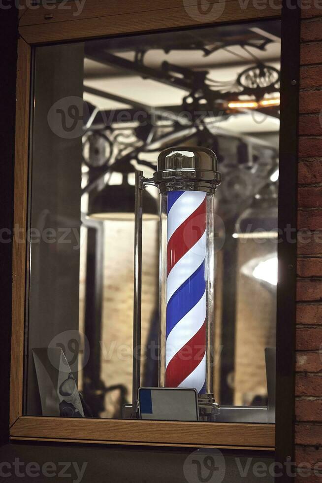 The famous symbol of a barber shop with it swirling red, blue and white stripes. photo