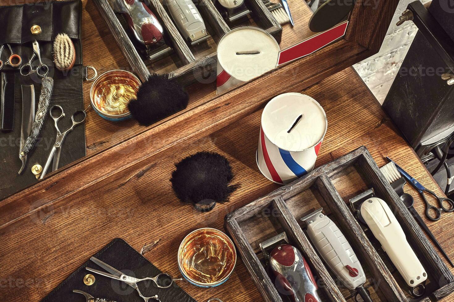 Hairdresser tools on wooden background. Top view on wooden table with scissors, comb, hairbrushes and hairclips, trimmer. photo