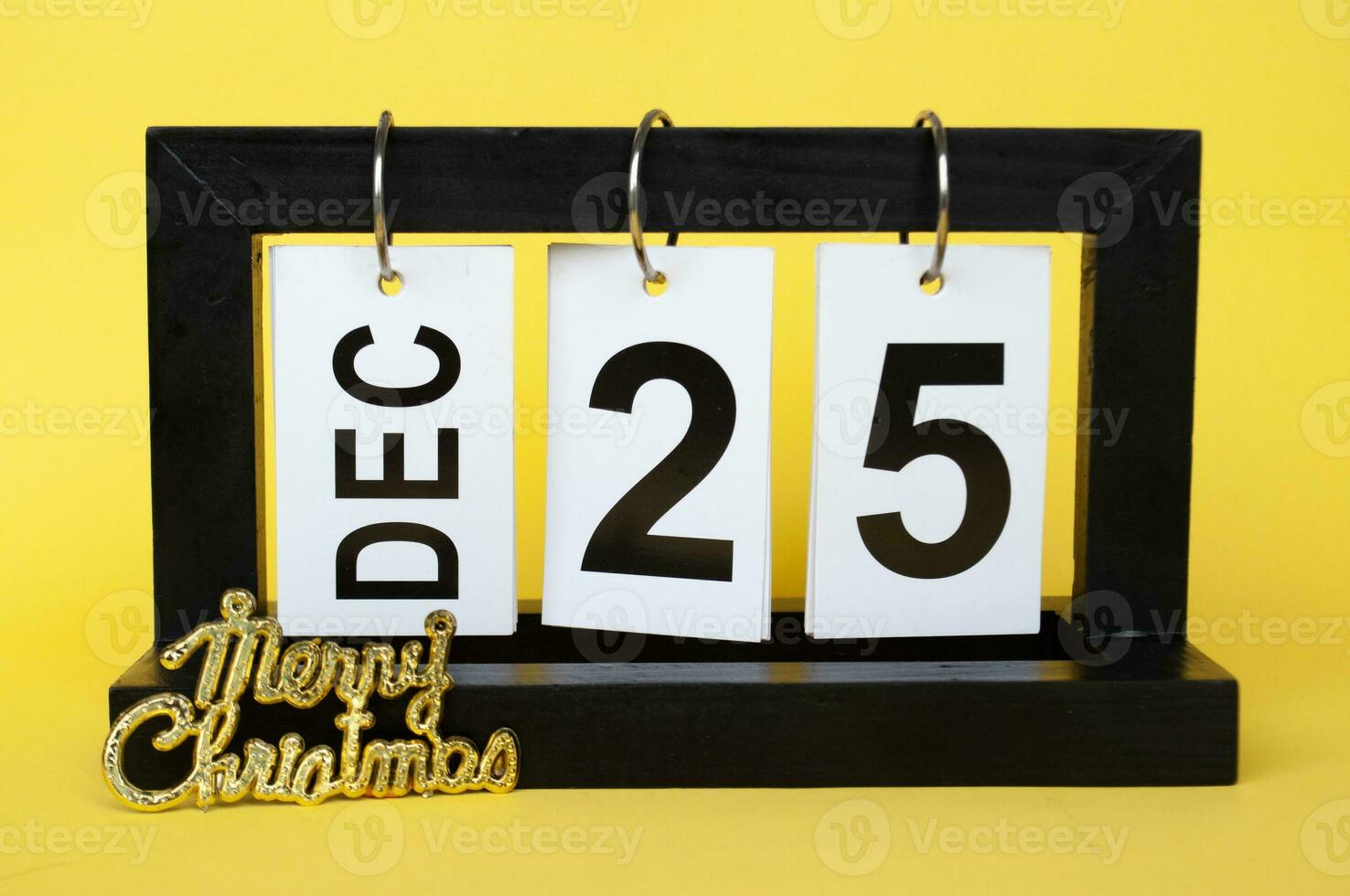 25 December calendar with Christmas wishes on yellow background. Christmas season concept photo