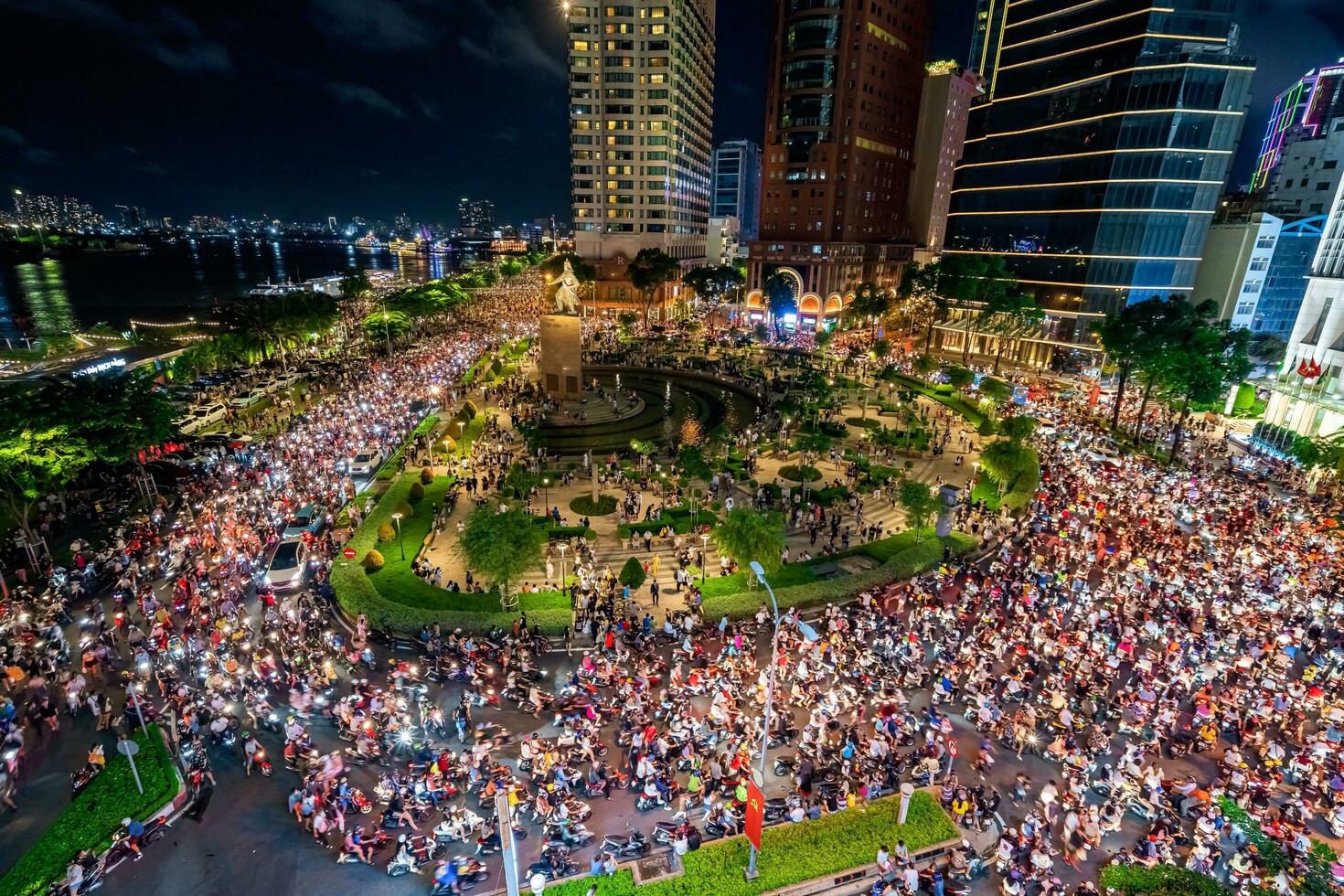 Ho Chi Minh city, Vietnam - Sep 2, 2023 View of Me Linh roundabout with heavy traffic near Bach Dang waterbus station port and Saigon river at blue hour photo