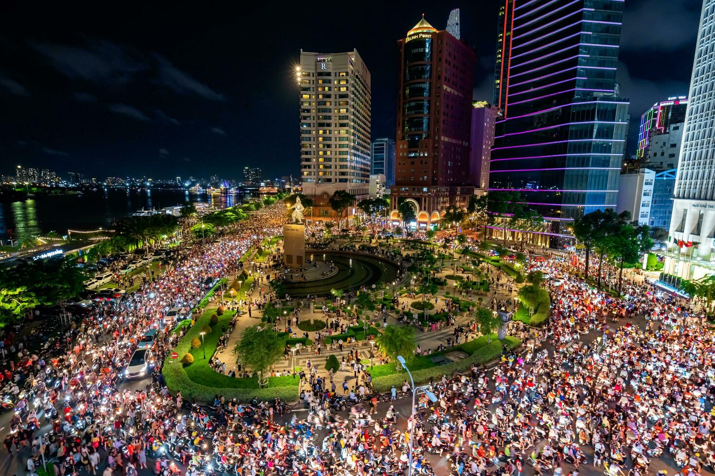 Ho Chi Minh city, Vietnam - Sep 2, 2023 View of Me Linh roundabout with heavy traffic near Bach Dang waterbus station port and Saigon river at blue hour photo