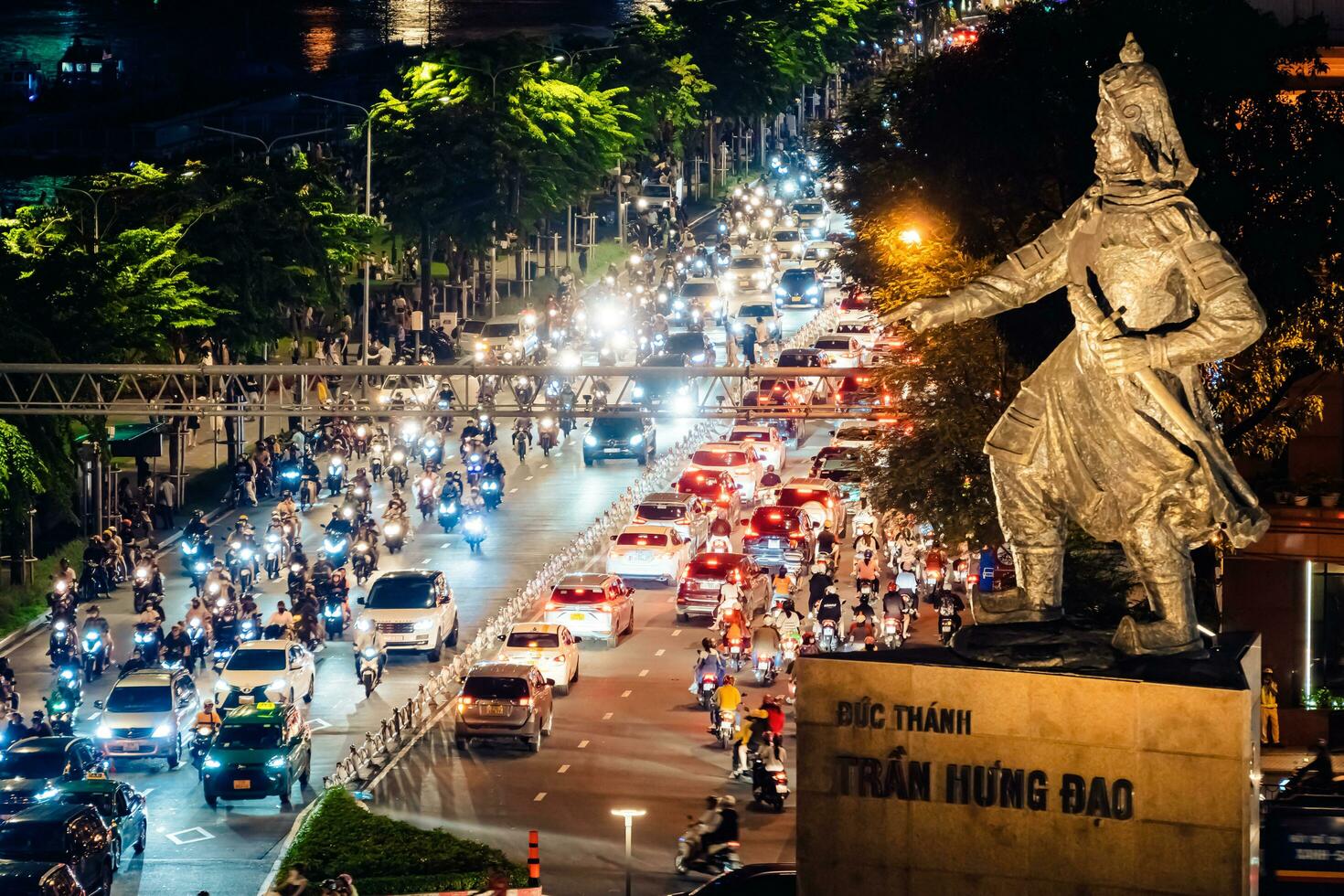 Ho Chi Minh city, Vietnam - Sep 2, 2023 View of Me Linh roundabout with heavy traffic near Bach Dang waterbus station port and Saigon river at blue hour photo