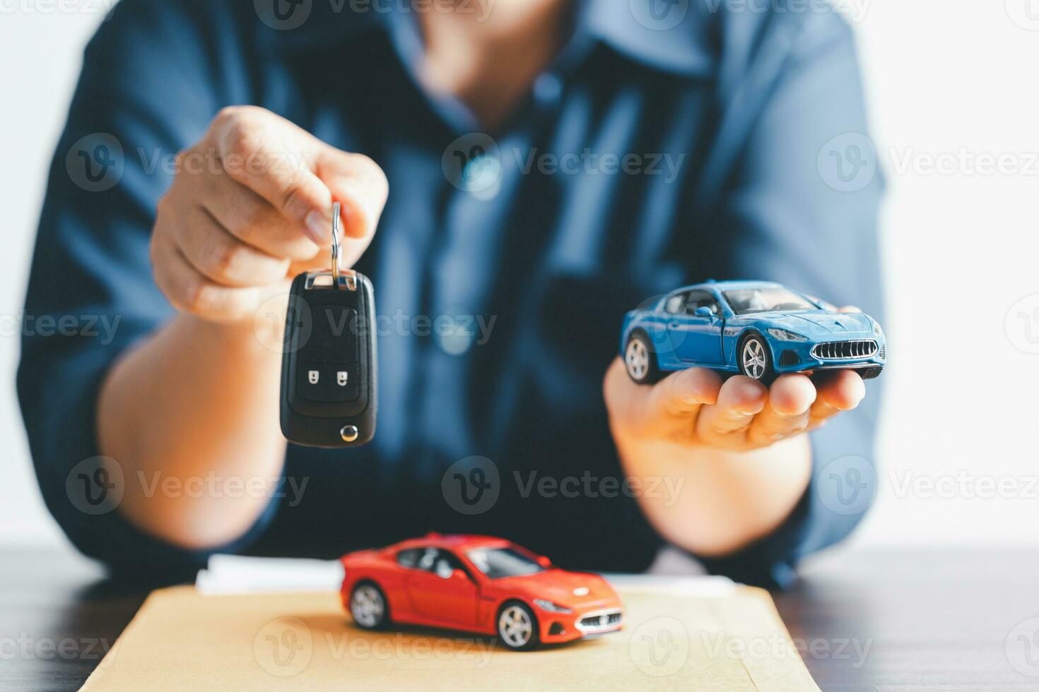 Hand holding car keys and a remote control for keyless entry. Car loan, contract agreement, buying and rent car concept, Sale person holding car key on hand. photo