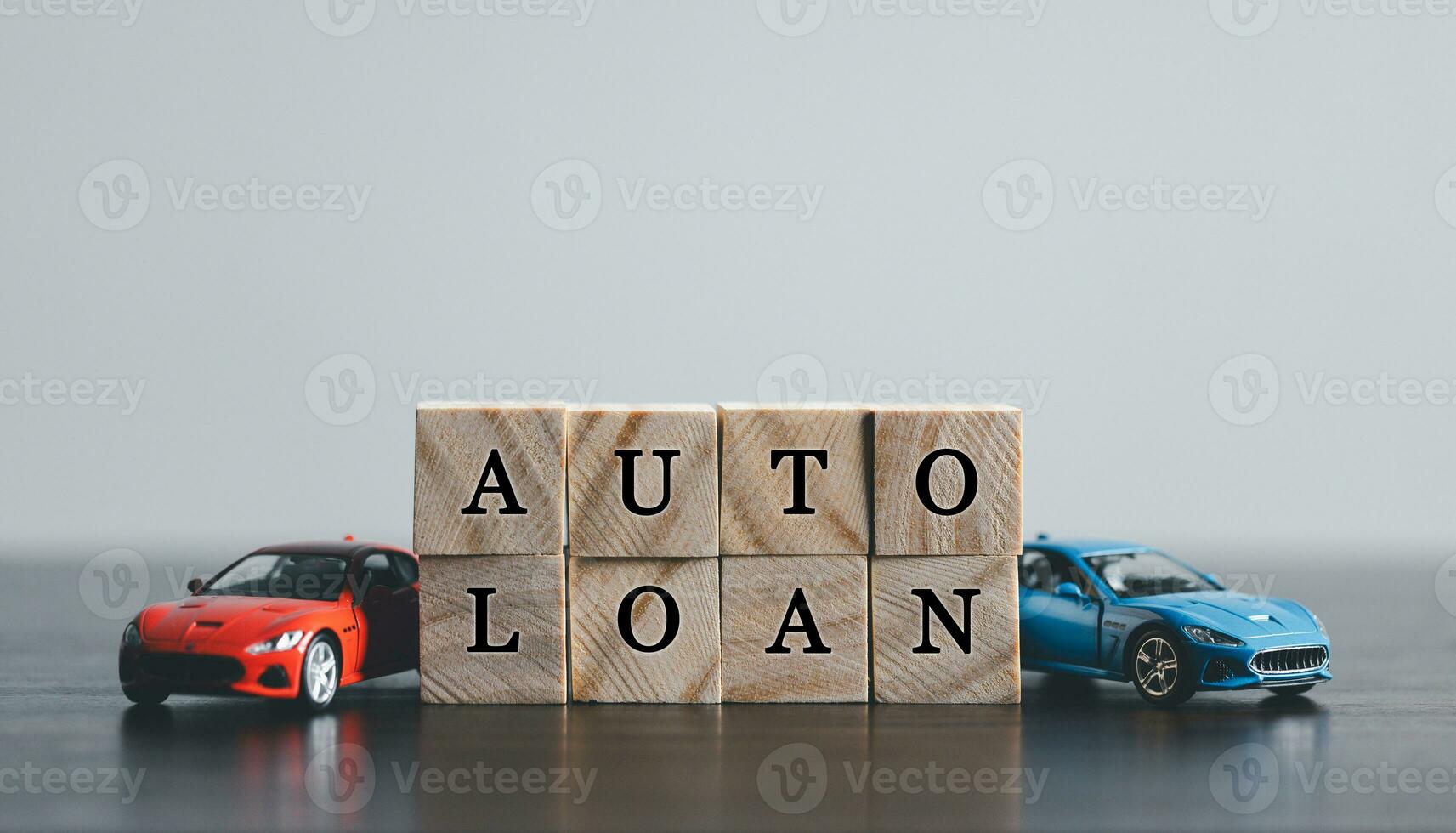 The word AUTO LOAN in the English language, written on wooden cubes. Finance and car loan, refinance, Investment and business concept with copy space. photo