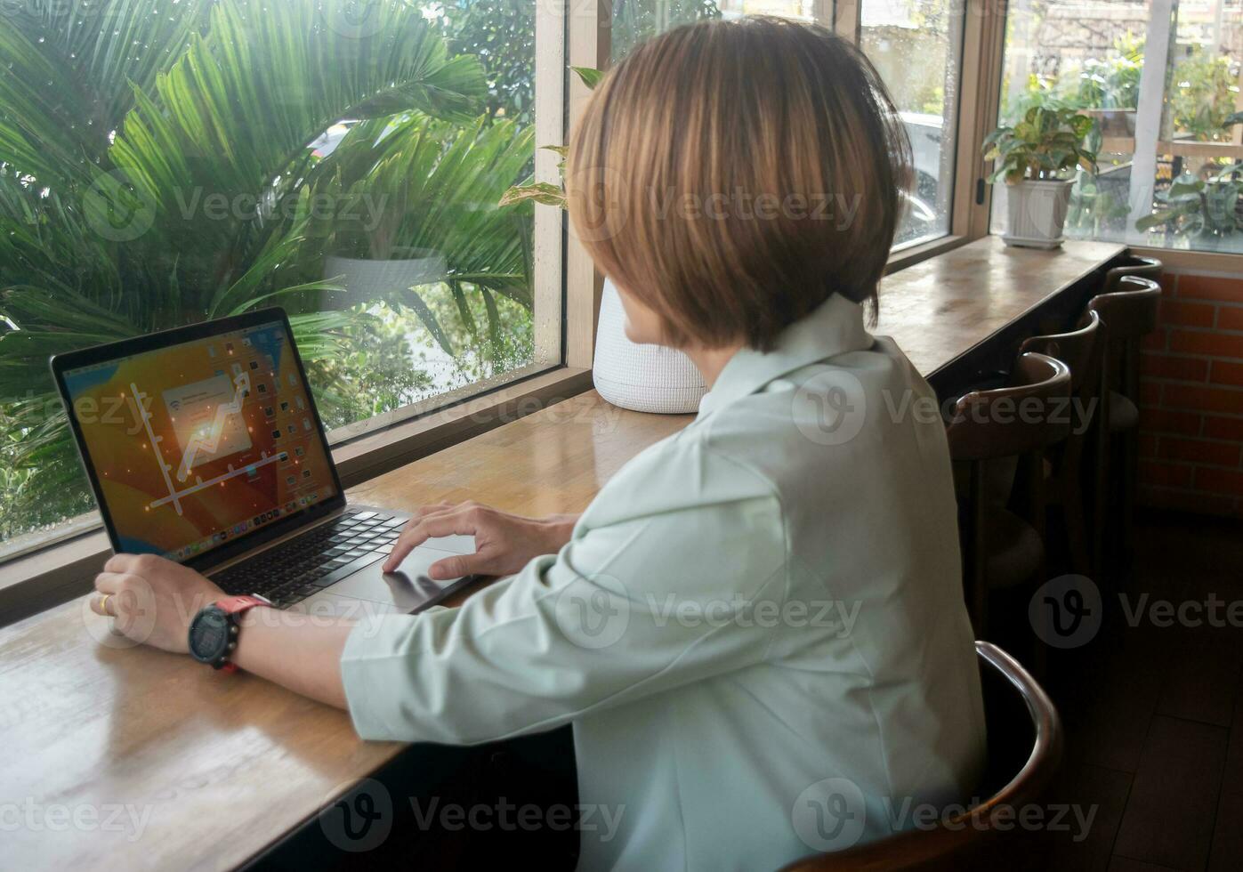 Freelance businesswoman wearing suit and sitting at the cafe working on laptop using soffware internet and checking email,developing new project concepts photo