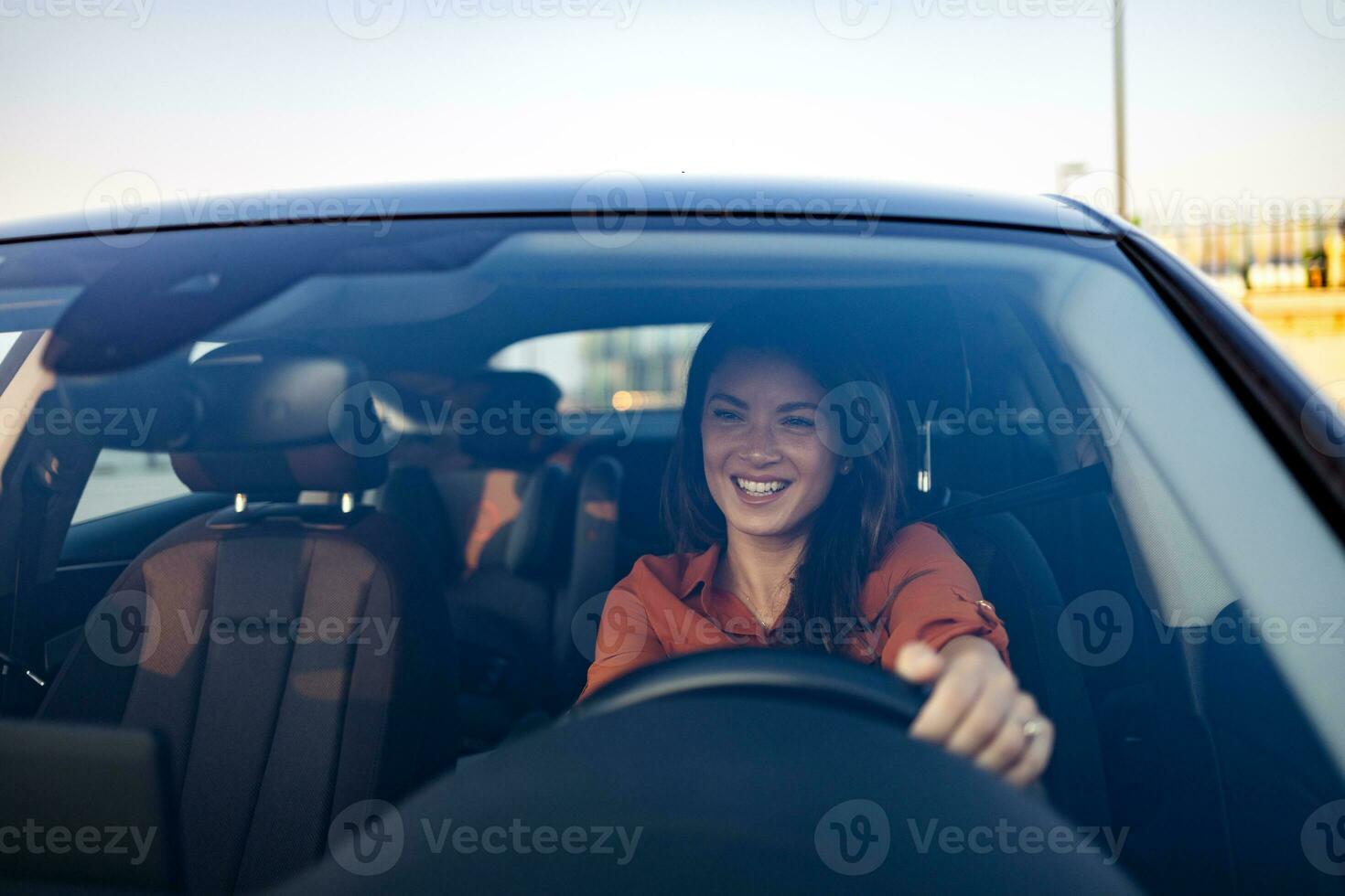 contento negocio mujer de viaje con su coche alrededor el ciudad. hermosa joven contento sonriente mujer conducción su nuevo coche a puesta de sol. foto