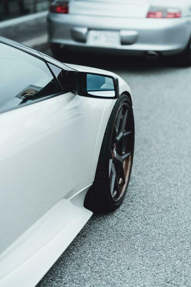 a white sports car parked next to a silver car photo