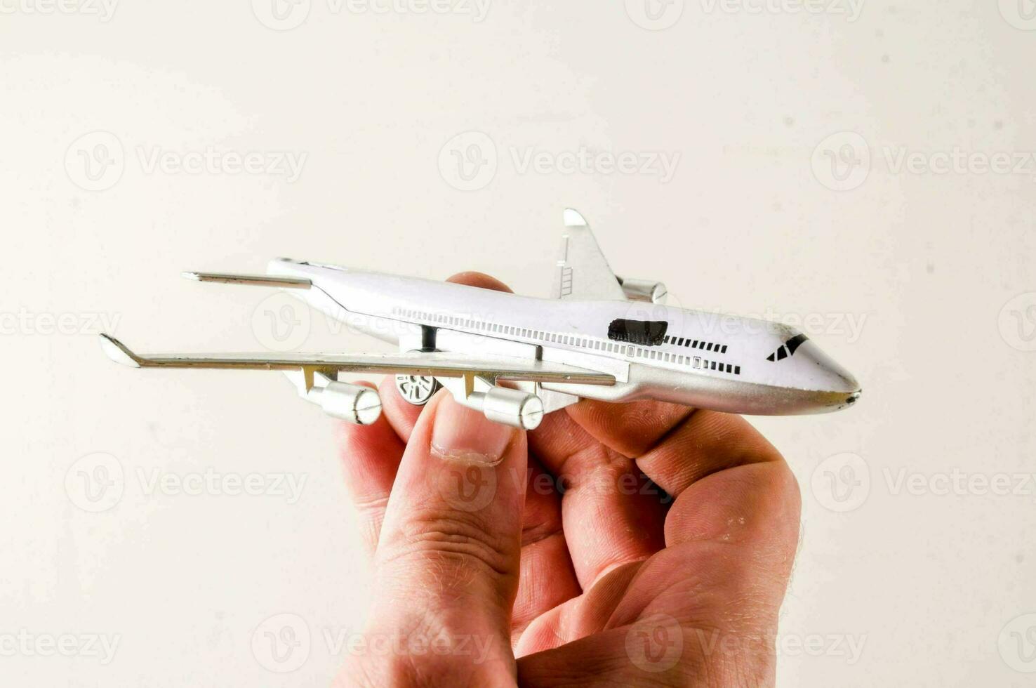 a person holding a paper airplane in front of a white background photo