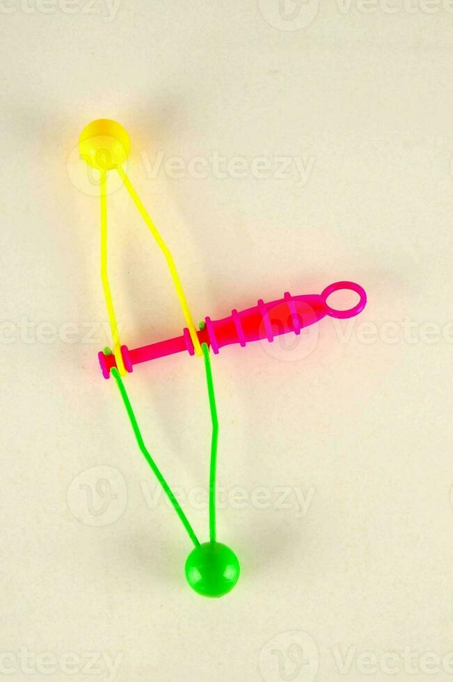 a plastic toy with a yellow and green bow photo