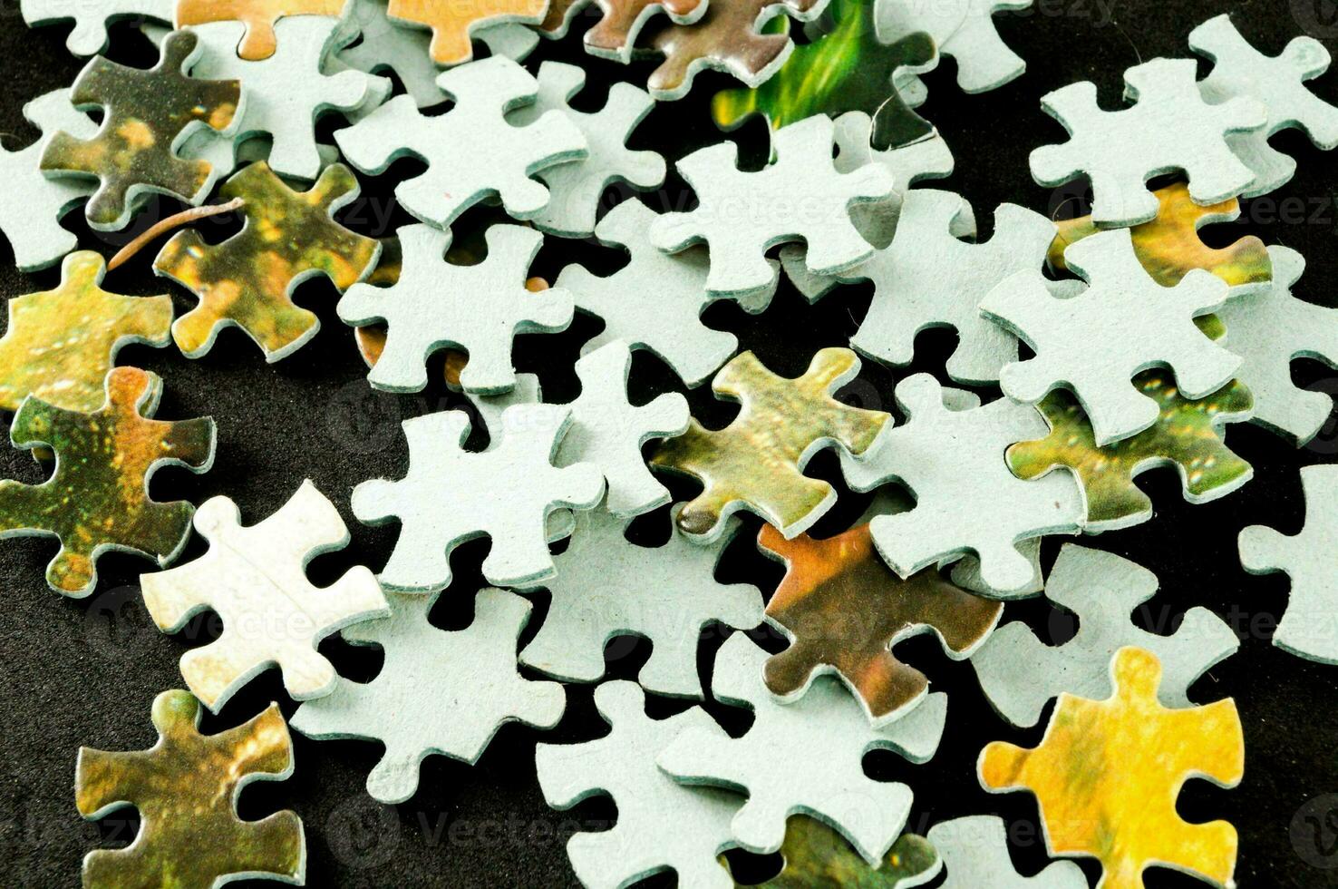 a pile of puzzle pieces on a white surface photo