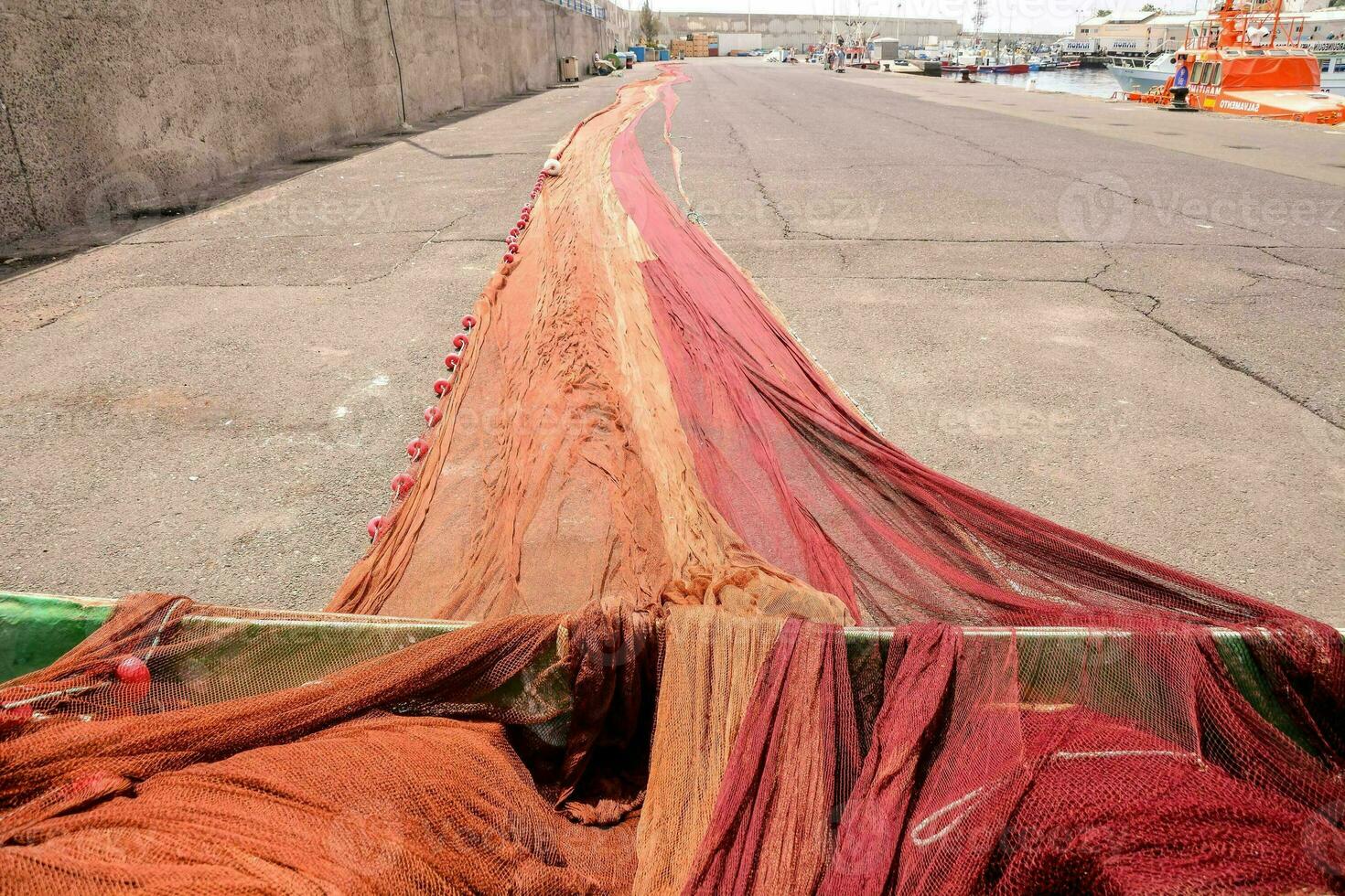 a long line of red and orange fishing nets photo