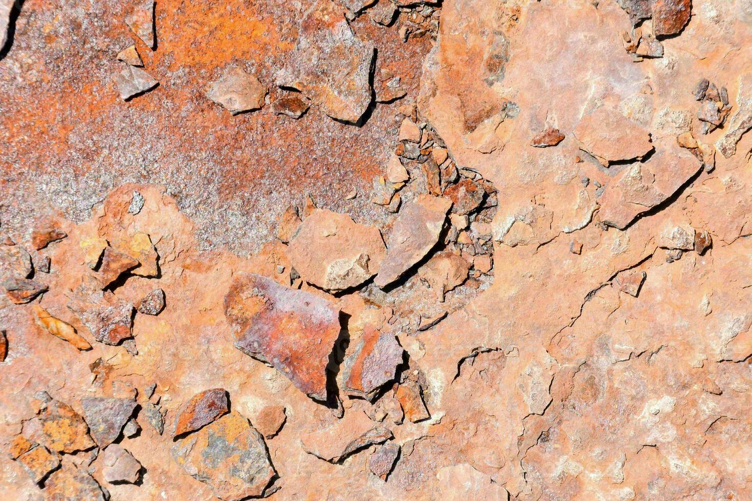 rusty metal wall with a few pebbles and rocks photo