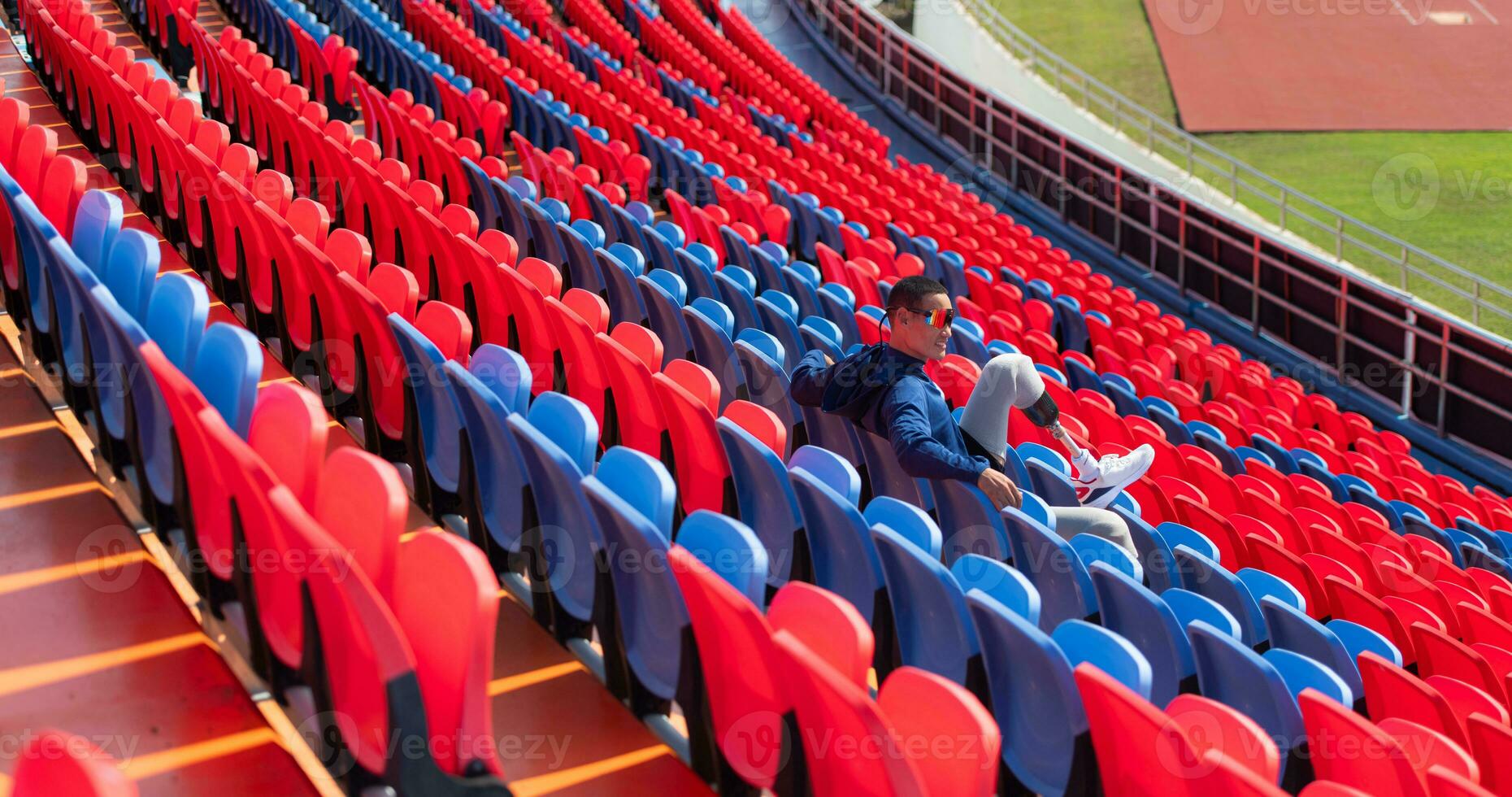 Disabled athletes prepare their bodies on amphitheater in a sports arena on a sunny day before entering a short-distance running competition photo