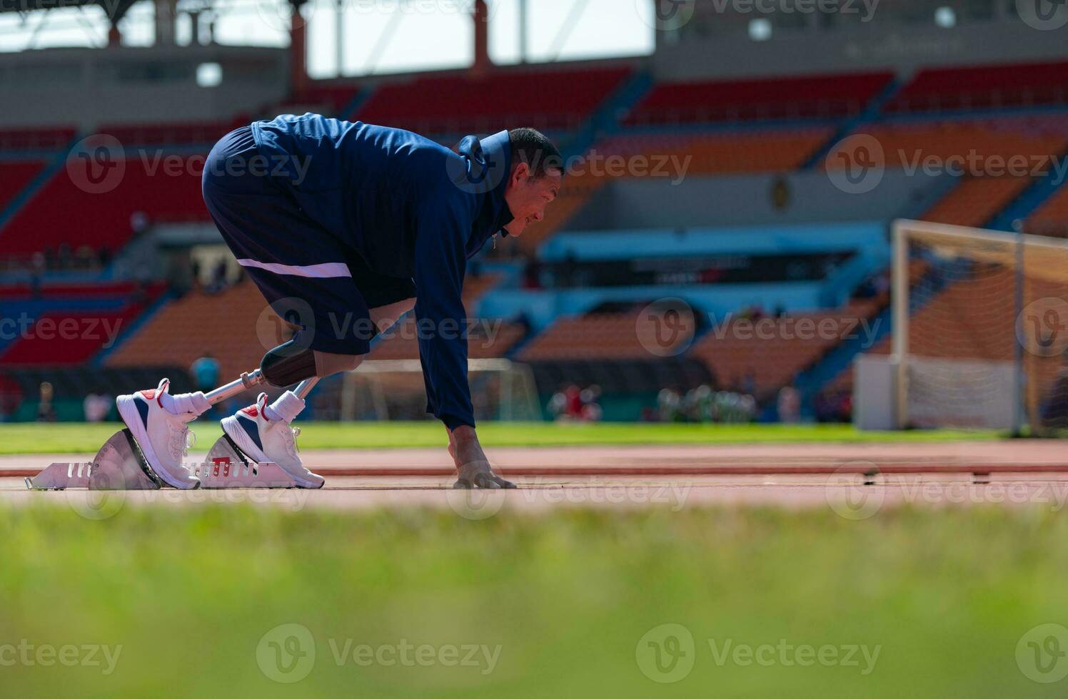 discapacitado Atletas preparar en comenzando posición Listo a correr en estadio pista foto