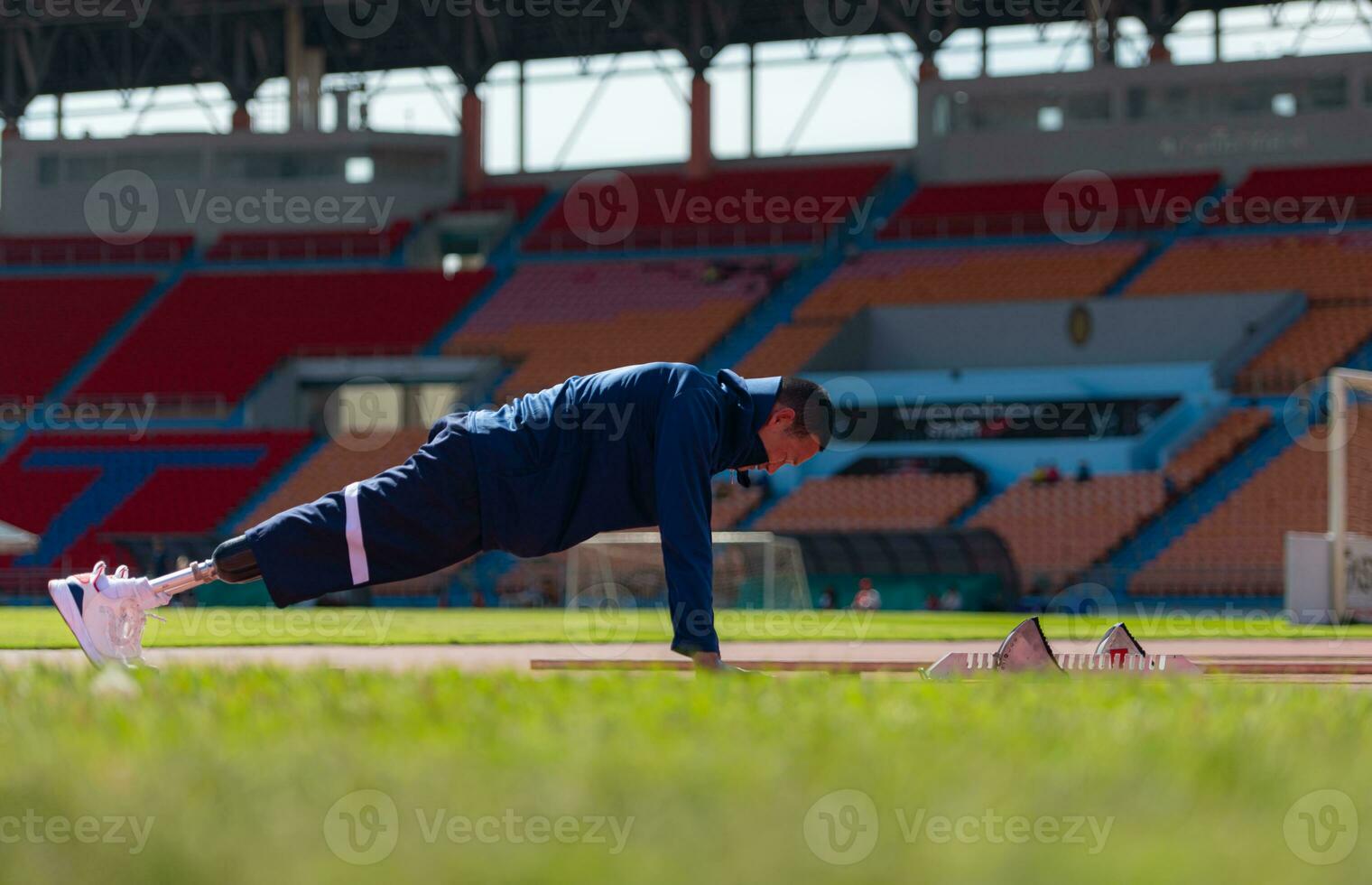 discapacitado atlético hombre extensión y calentamiento arriba antes de corriendo en estadio pista foto