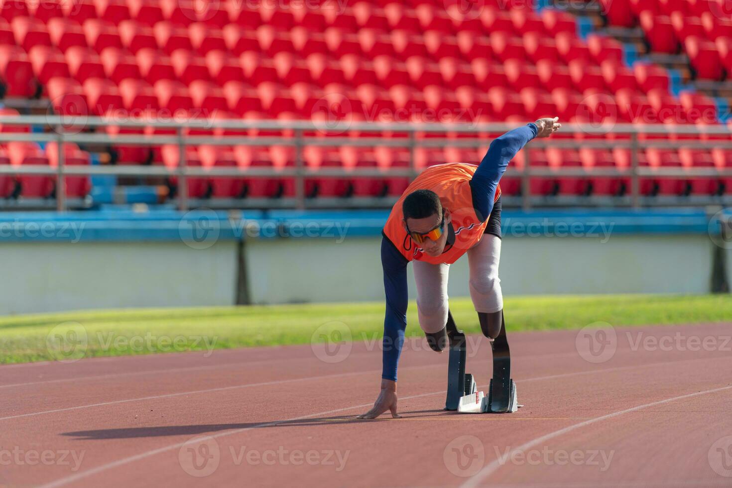 Disabled athletes prepare in starting position ready to run on stadium track photo