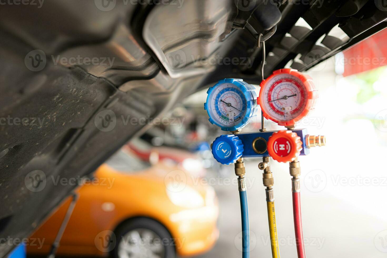 Car mechanic working in auto repair shop, inspecting the operation of the car's air conditioner and refrigerant. photo