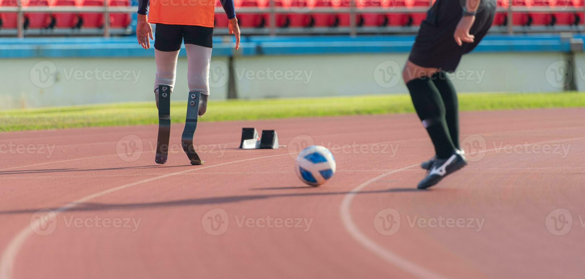 Soccer player kicking the ball on the track in the stadium with disabled athletes training sessions. photo