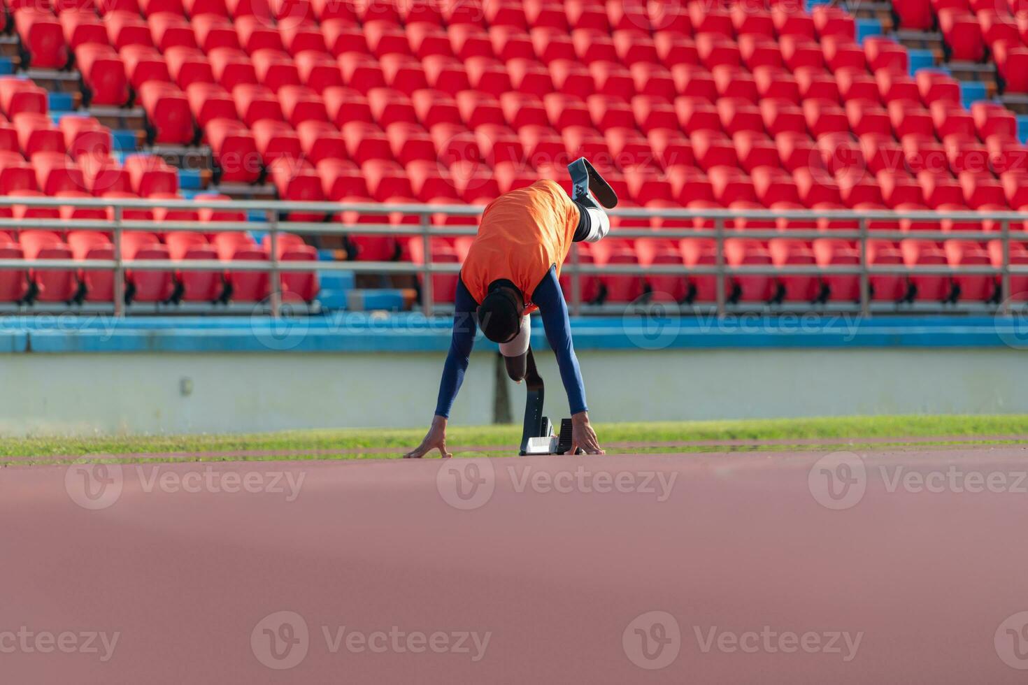 Disabled athletes prepare in starting position ready to run on stadium track photo