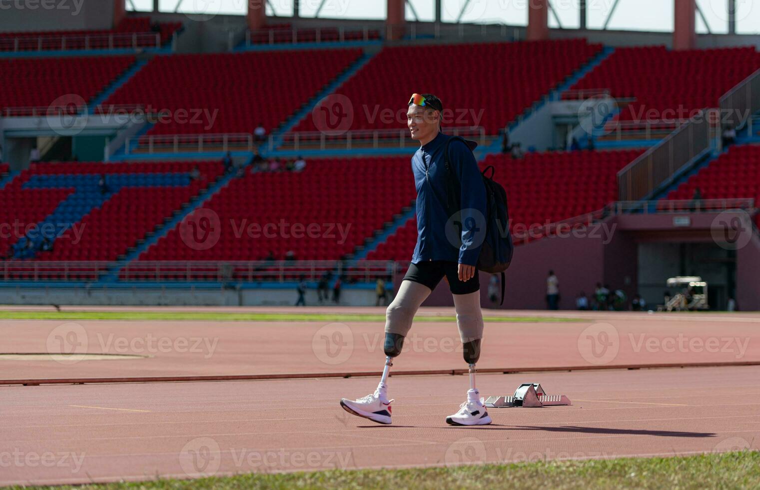 Disabled athletes prepare their bodies on amphitheater in a sports arena on a sunny day before entering a short-distance running competition photo