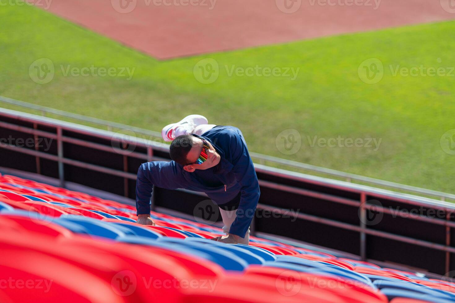 Disabled athletes prepare their bodies on amphitheater in a sports arena on a sunny day before entering a short-distance running competition photo