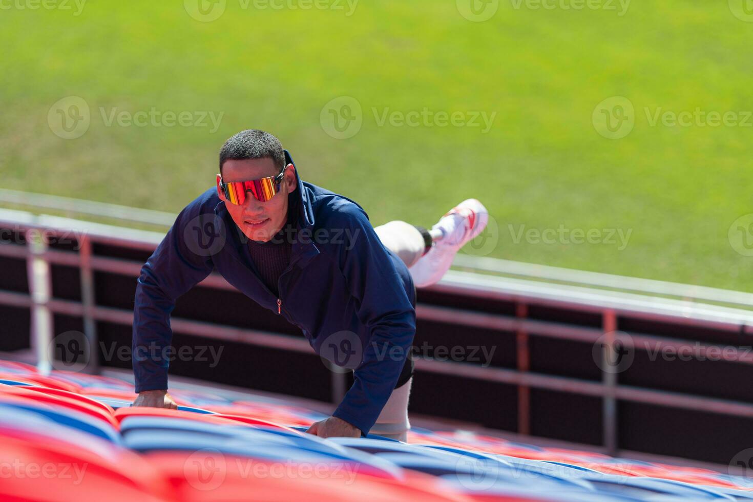 Disabled athletes prepare their bodies on amphitheater in a sports arena on a sunny day before entering a short-distance running competition photo