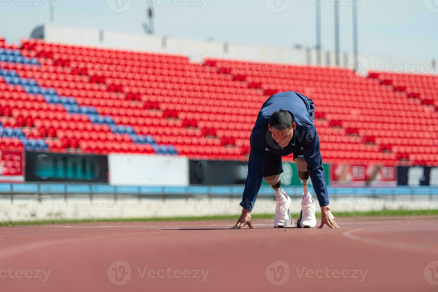 Disabled athletes prepare in starting position ready to run on stadium track photo