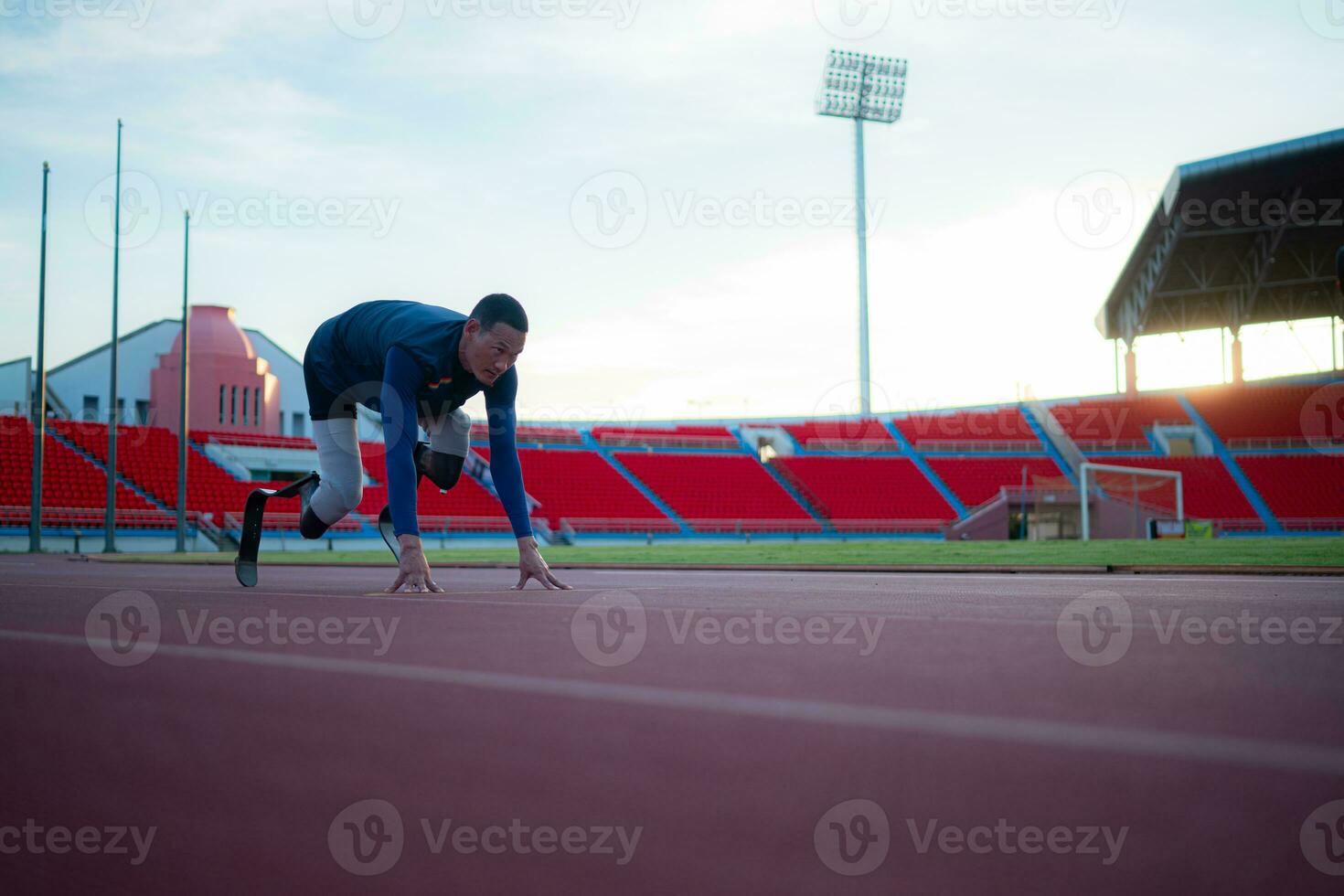 Disabled athletes prepare in starting position ready to run on stadium track photo