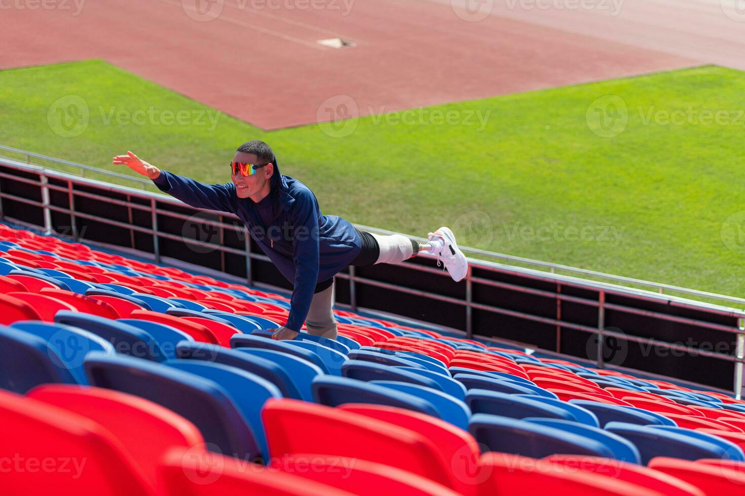 Disabled athletes prepare their bodies on amphitheater in a sports arena on a sunny day before entering a short-distance running competition photo