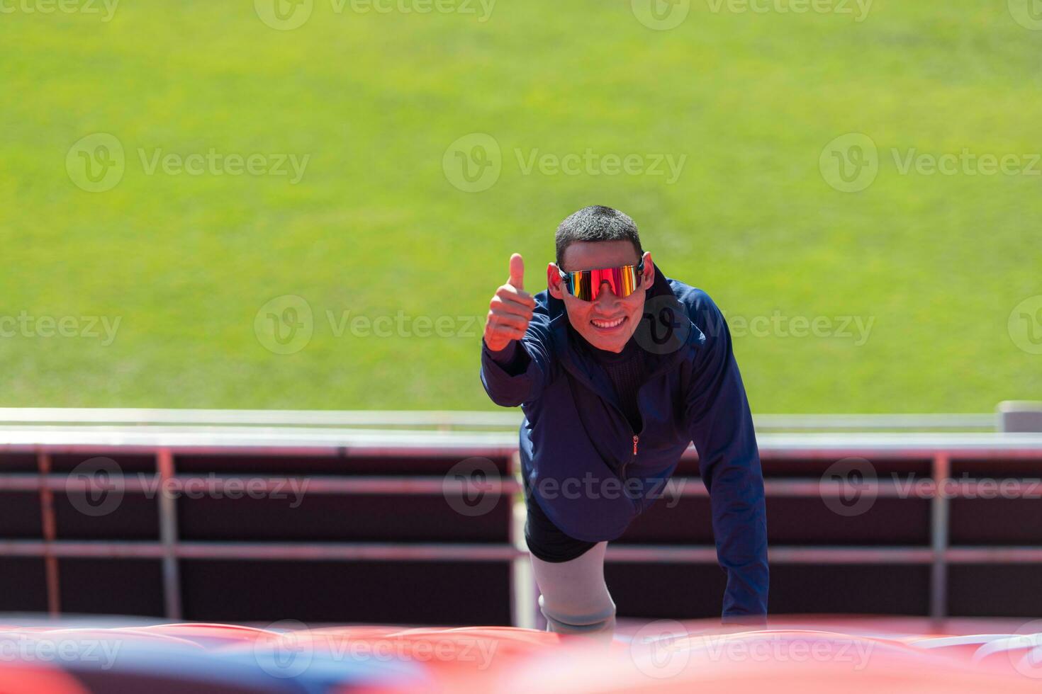 Disabled athletes prepare their bodies on amphitheater in a sports arena on a sunny day before entering a short-distance running competition photo