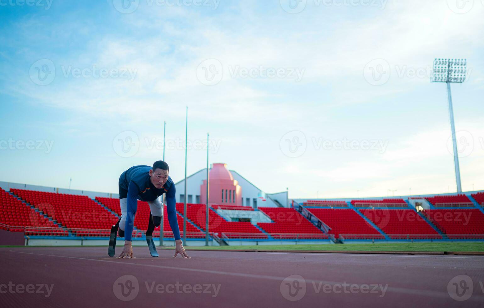 Disabled athletes prepare in starting position ready to run on stadium track photo